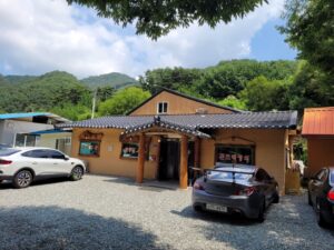 곤드레 정식 식당, 주차 차량, 푸른 산 배경
