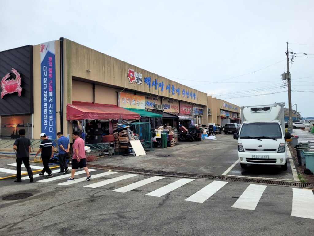 태안 백사장 어촌계 수산시장 건물 외관과 시장 앞 주차 공간