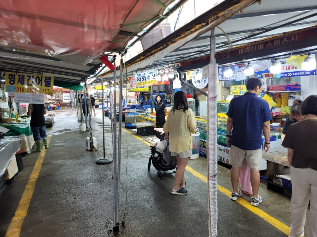 수산물 점포와 수조가 이어진 백사장 어촌계 수산시장 내부 통로