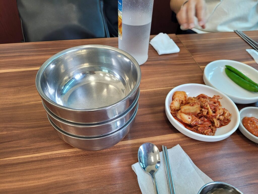 국수 뼈 그릇과 김치가 놓인 테이블