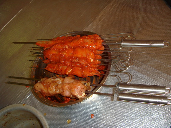 붉은 양념 생 닭고기 꼬치, 후추 뿌린 금속 꼬치 준비
