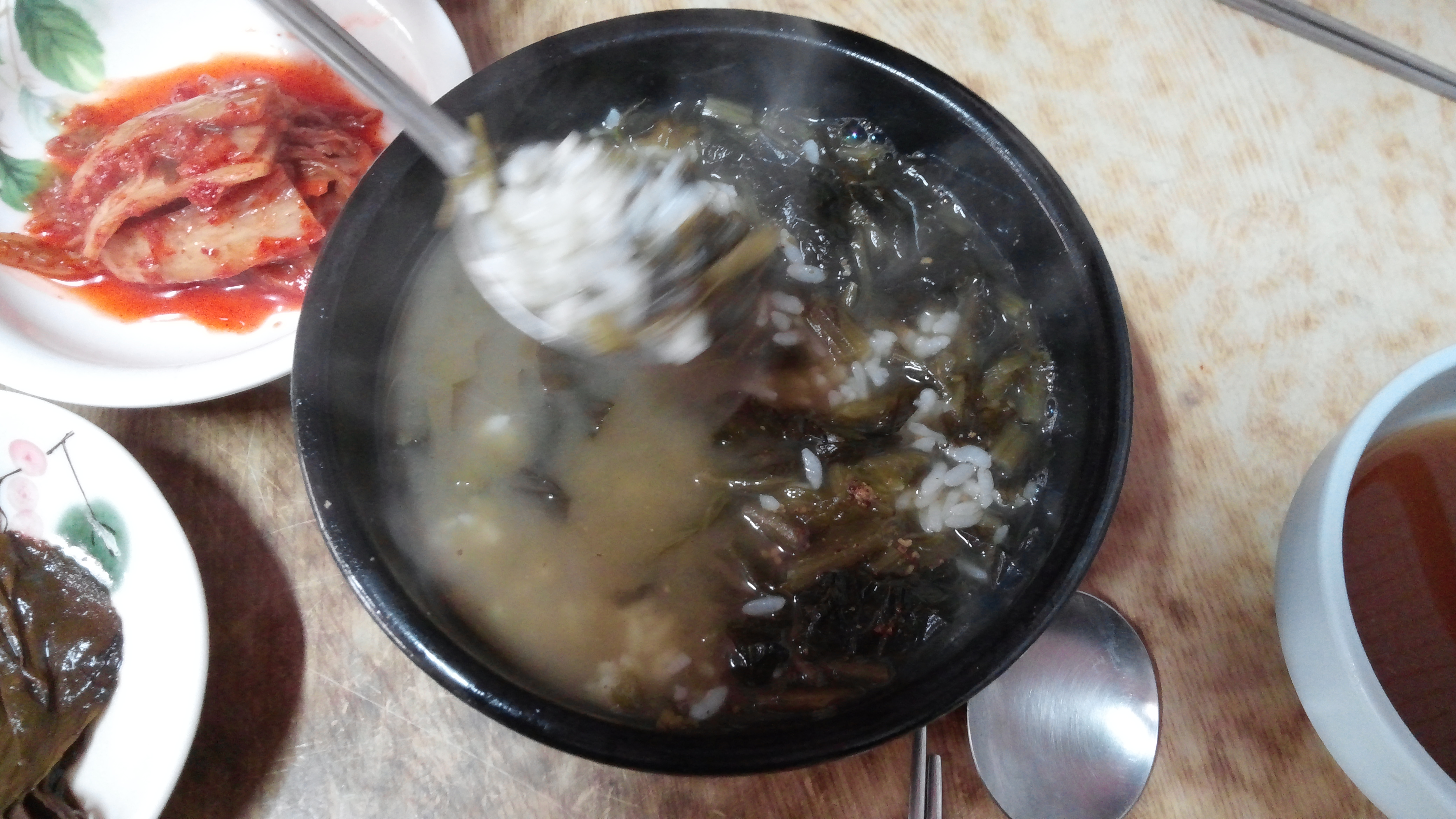 김치 반찬과 김 나는 시래기국, 밥 숟가락으로 뜨는