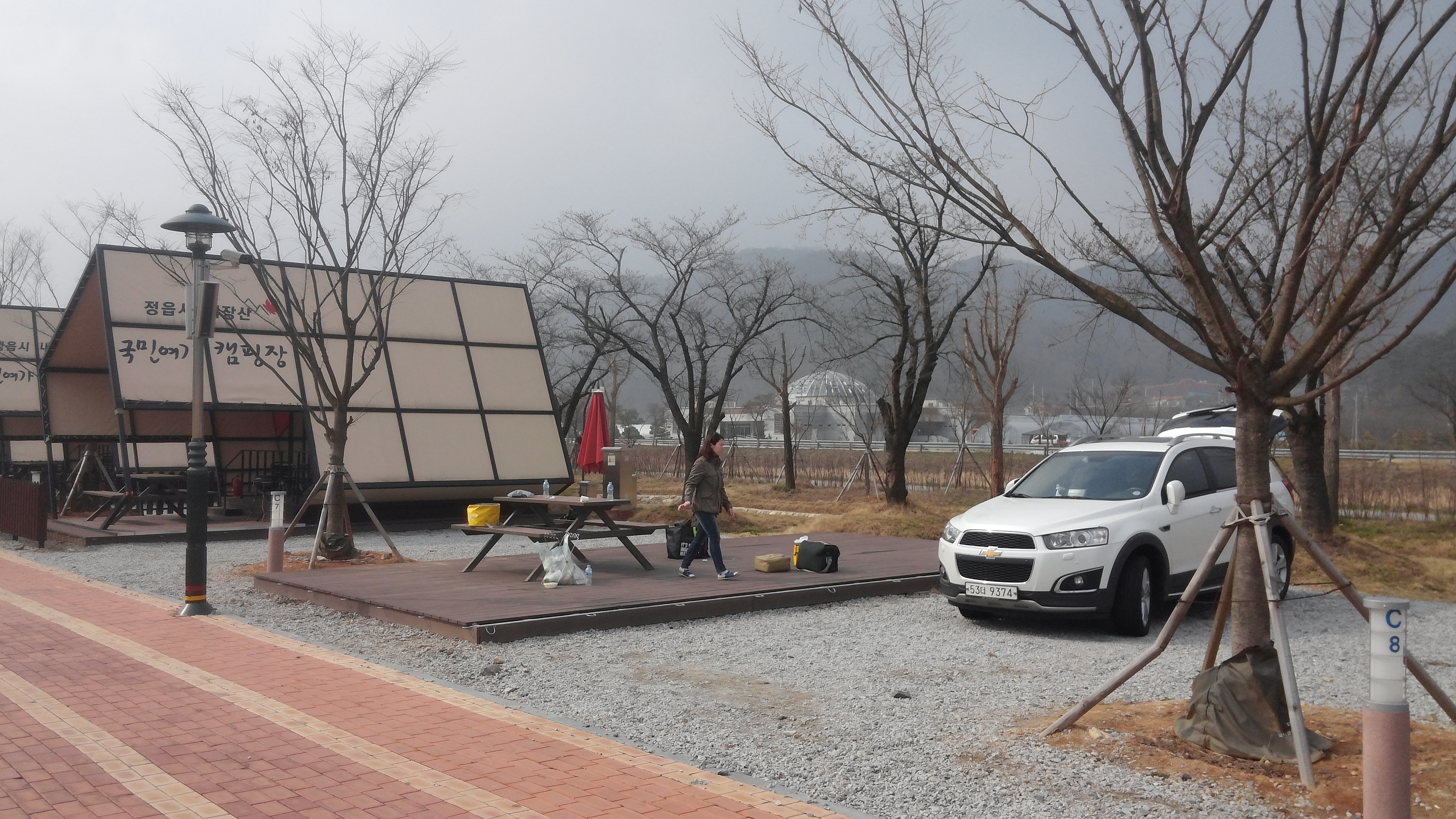 국민여가 캠핑장, 흰색 SUV, 야외 피크닉 테이블, 앙상한 겨울나무.