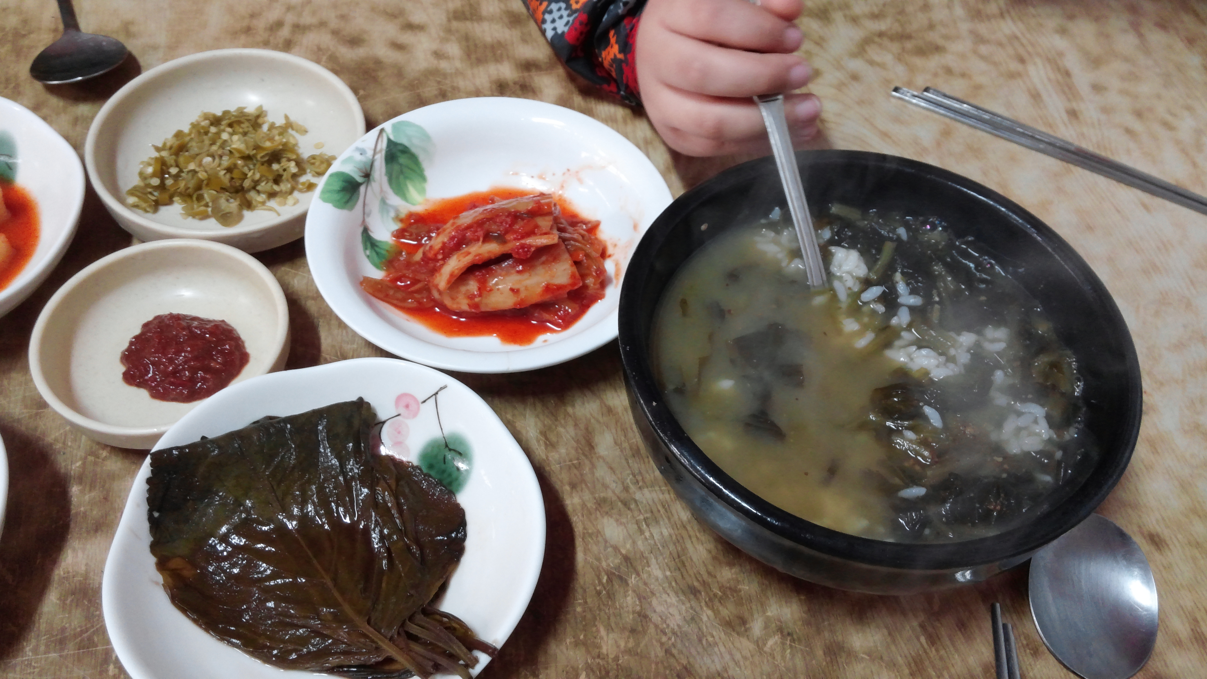 따끈한 국밥, 김치, 깻잎, 다양한 한식 반찬 식탁