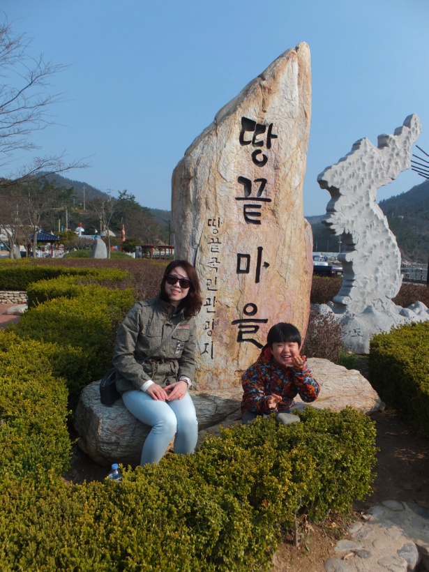땅끝마을 표지석 옆 밝은 미소와 포즈, 한반도 조형물