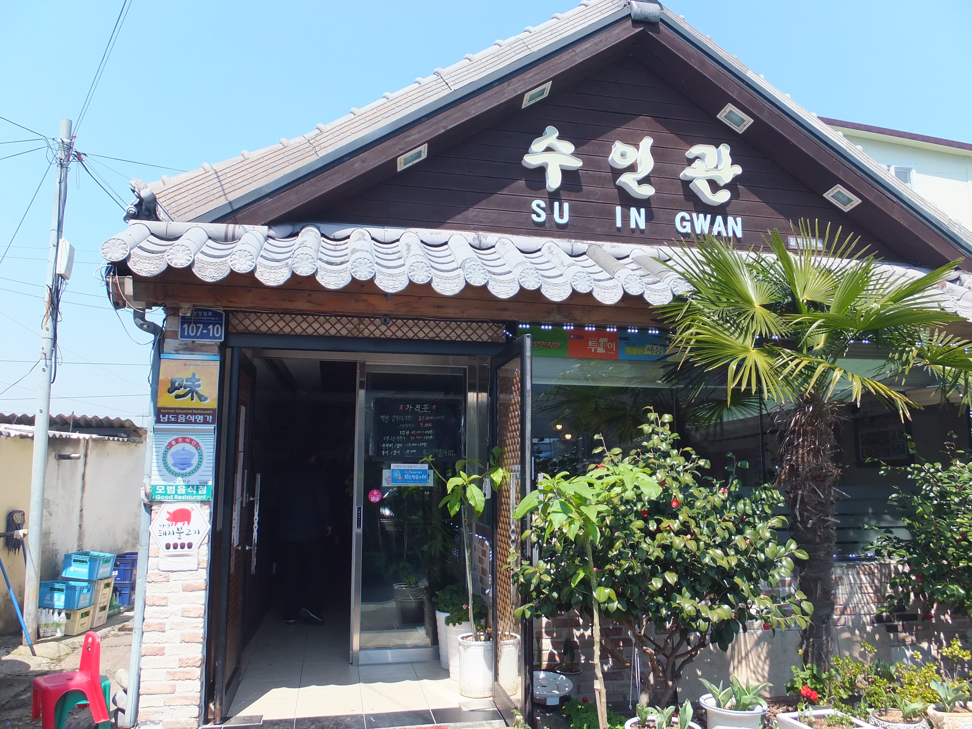 수인관 전통 기와 식당 외관, 푸른 하늘, 야자수