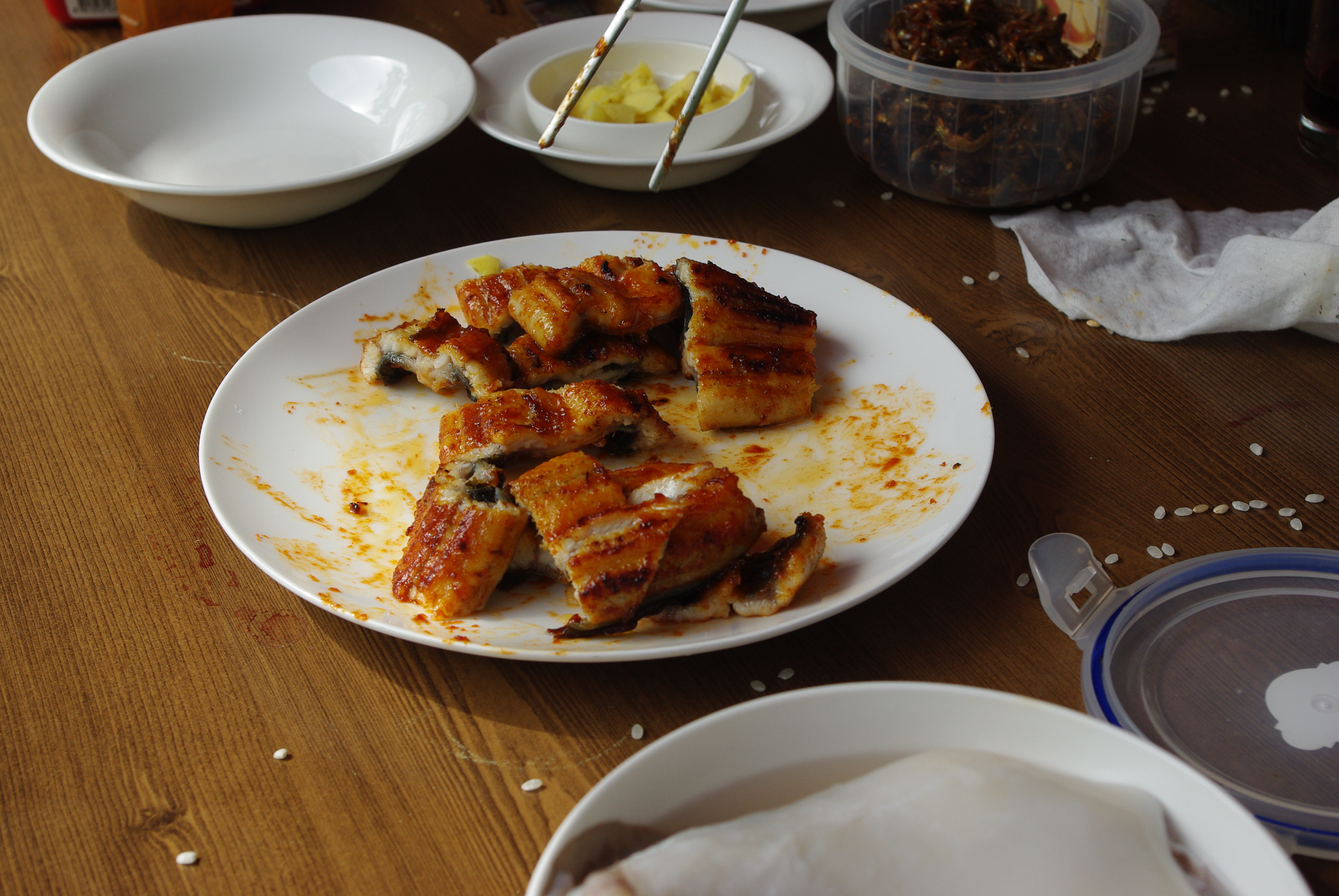 양념 장어구이 흰 접시, 나무 식탁 위 젓가락 반찬