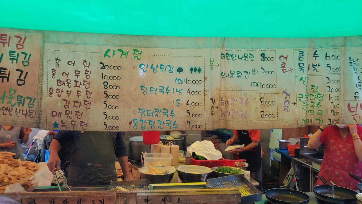 수제 메뉴판 아래 한국 시장 길거리 음식 준비