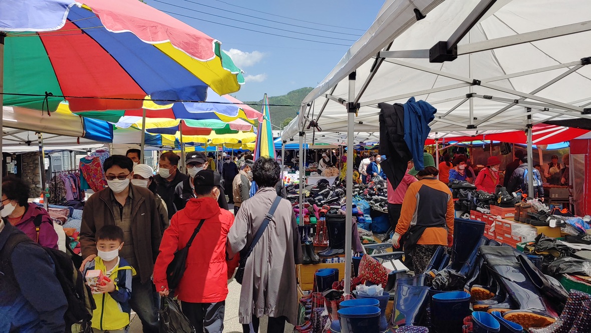 활기찬 야외 전통 시장, 알록달록 천막 아래 의류 신발 판매
