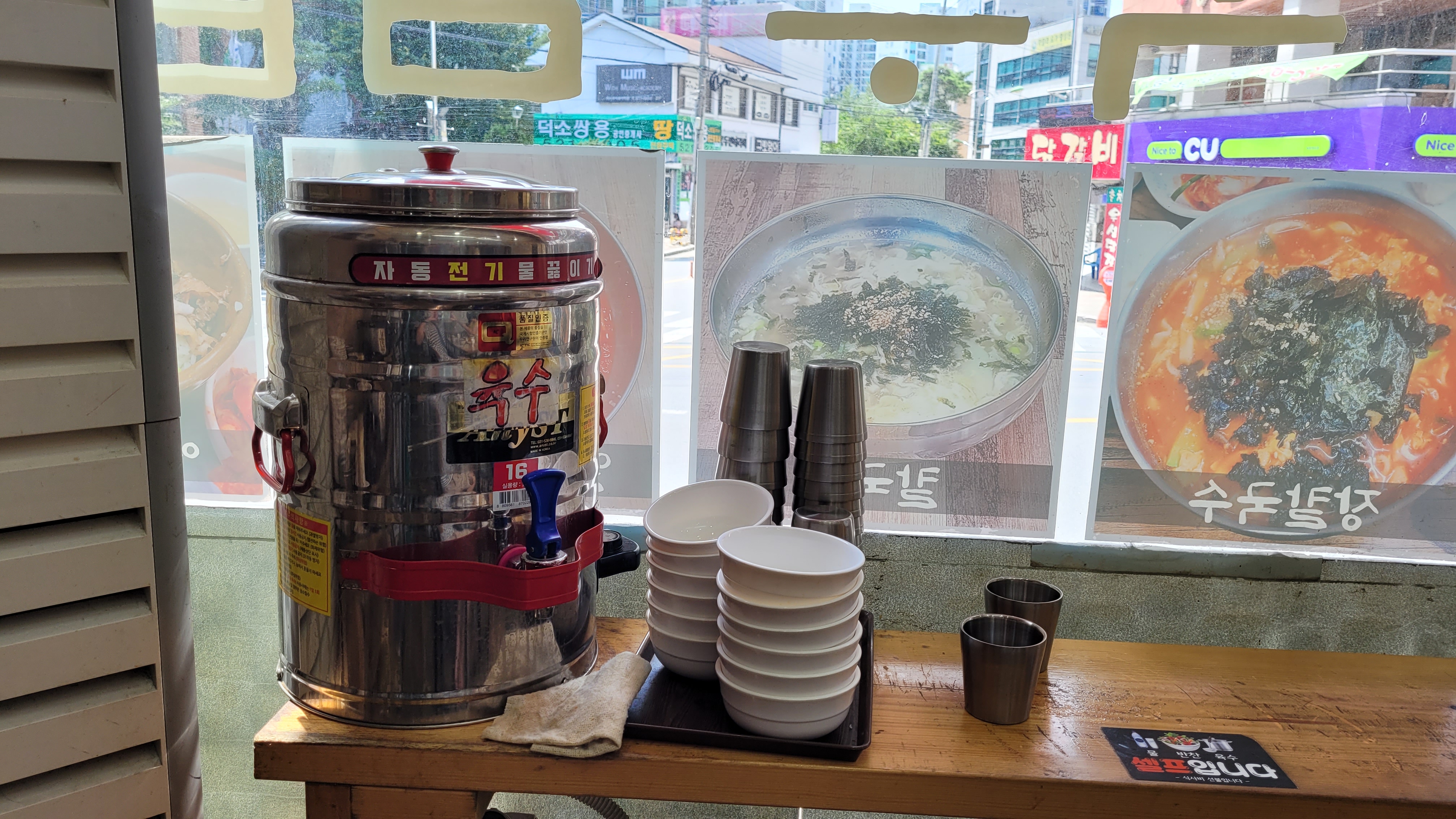 육수통, 그릇, 컵, 칼국수 메뉴 포스터 진열된 셀프 코너