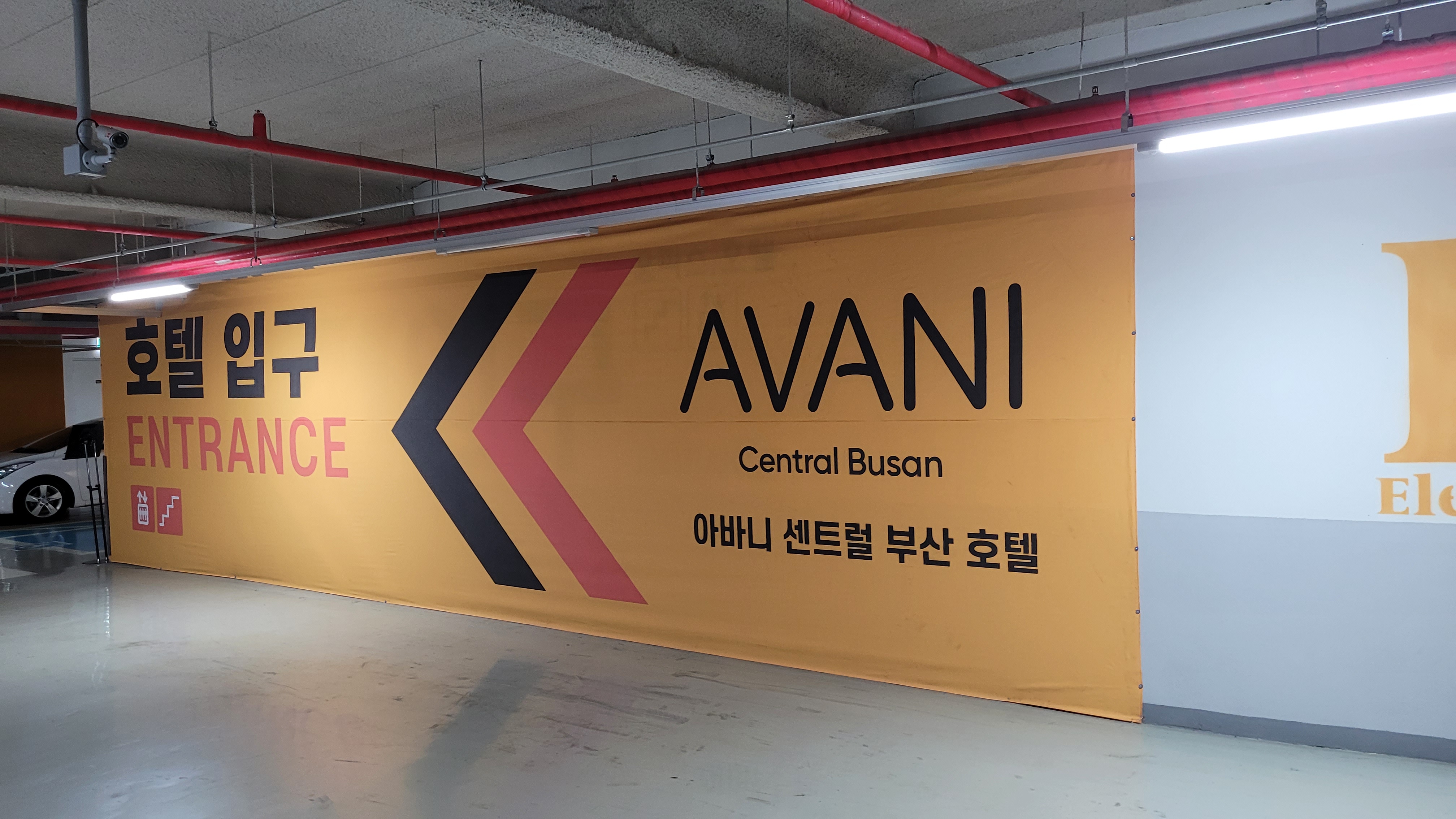 지하 주차장 노란색 아바니 센트럴 부산 호텔 입구 배너
