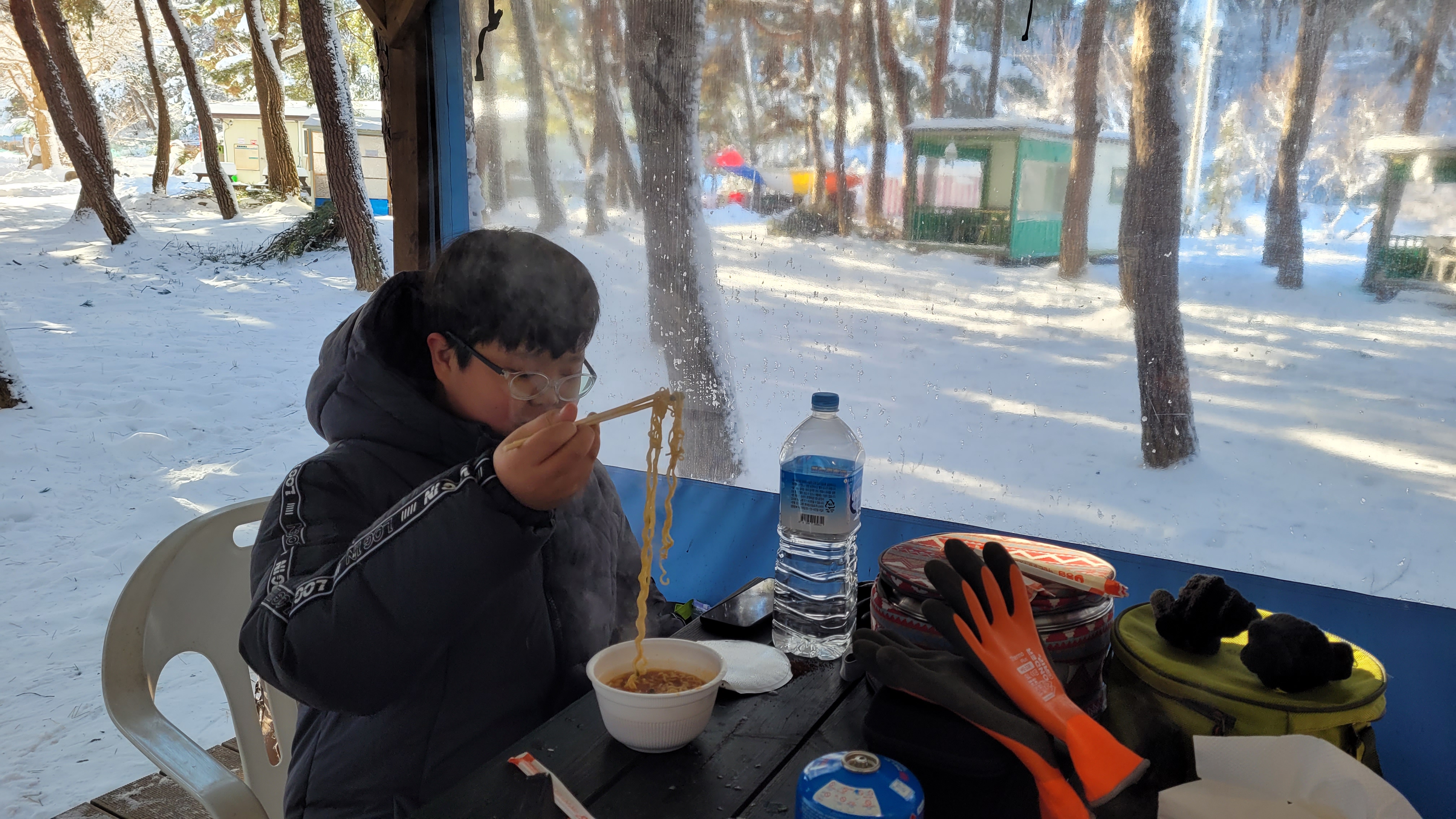 아이 겨울 눈 덮인 숲 캠핑장에서 따뜻한 라면 먹는 중