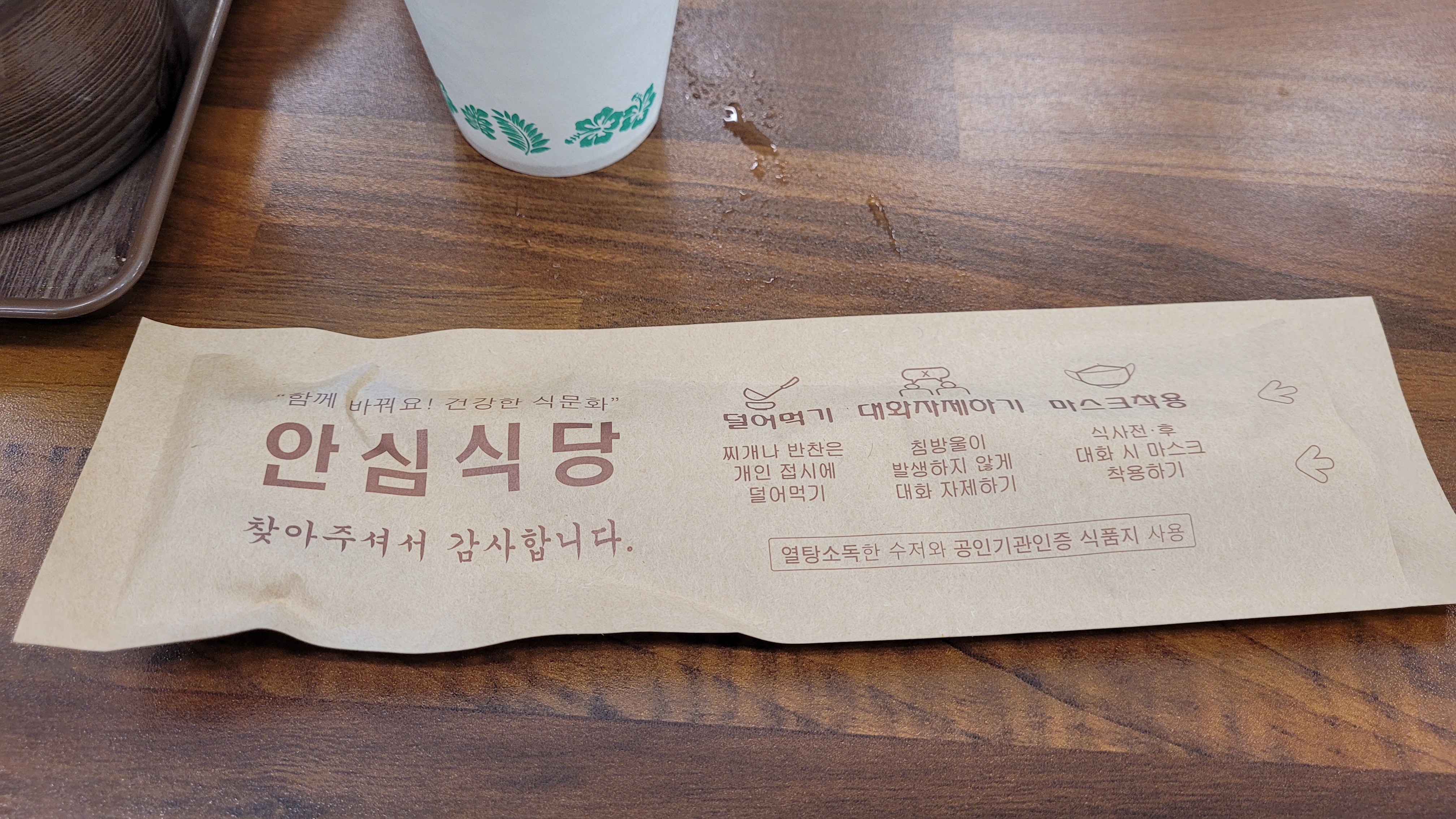 안심 식당 안전 수칙 인쇄된 갈색 종이 나무 테이블