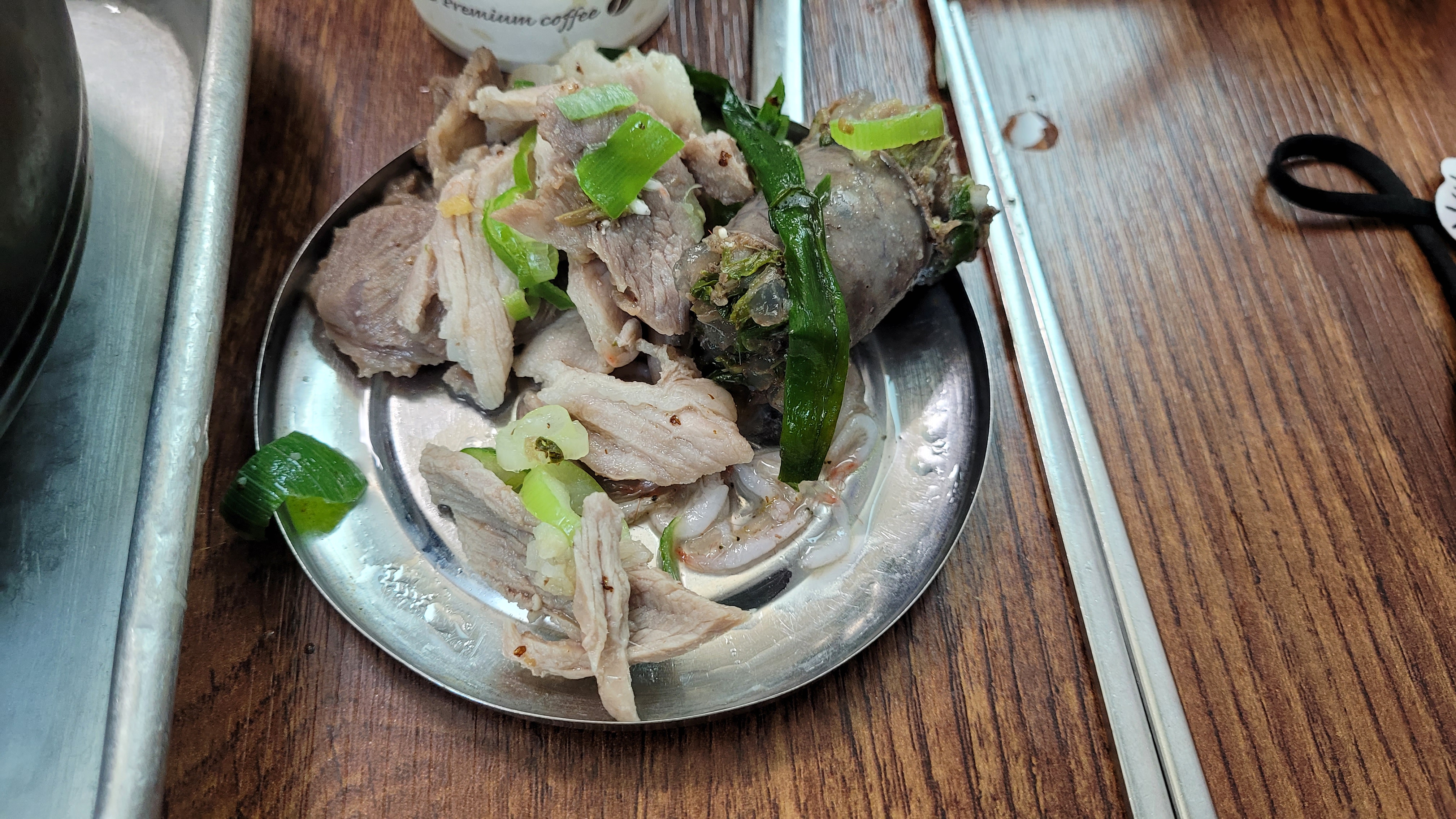 모듬 순대, 내장, 수육, 파 곁들인 따뜻한 한식 요리