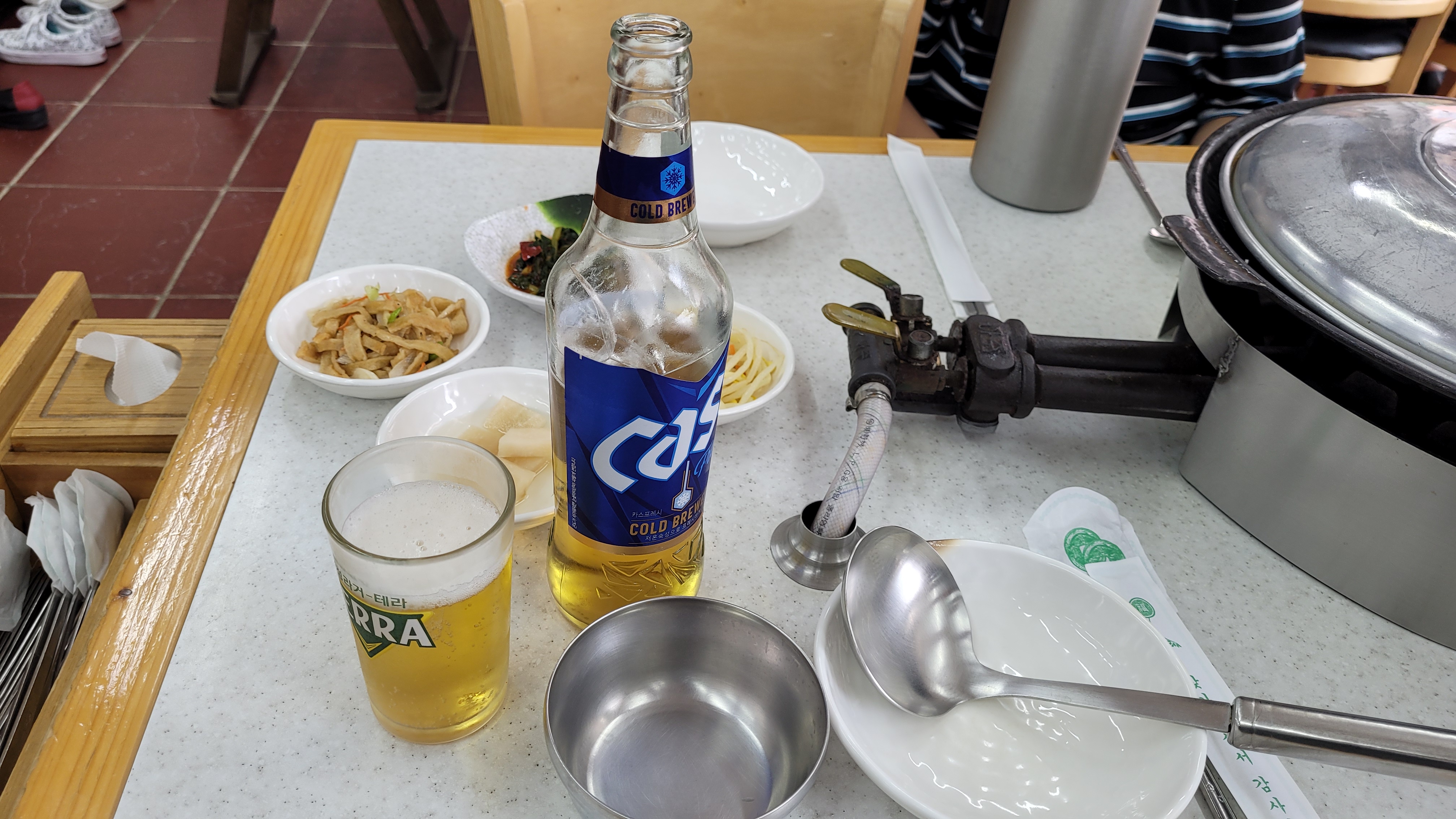 카스 맥주병, 테라 맥주잔, 반찬 그릇, 찌개 냄비