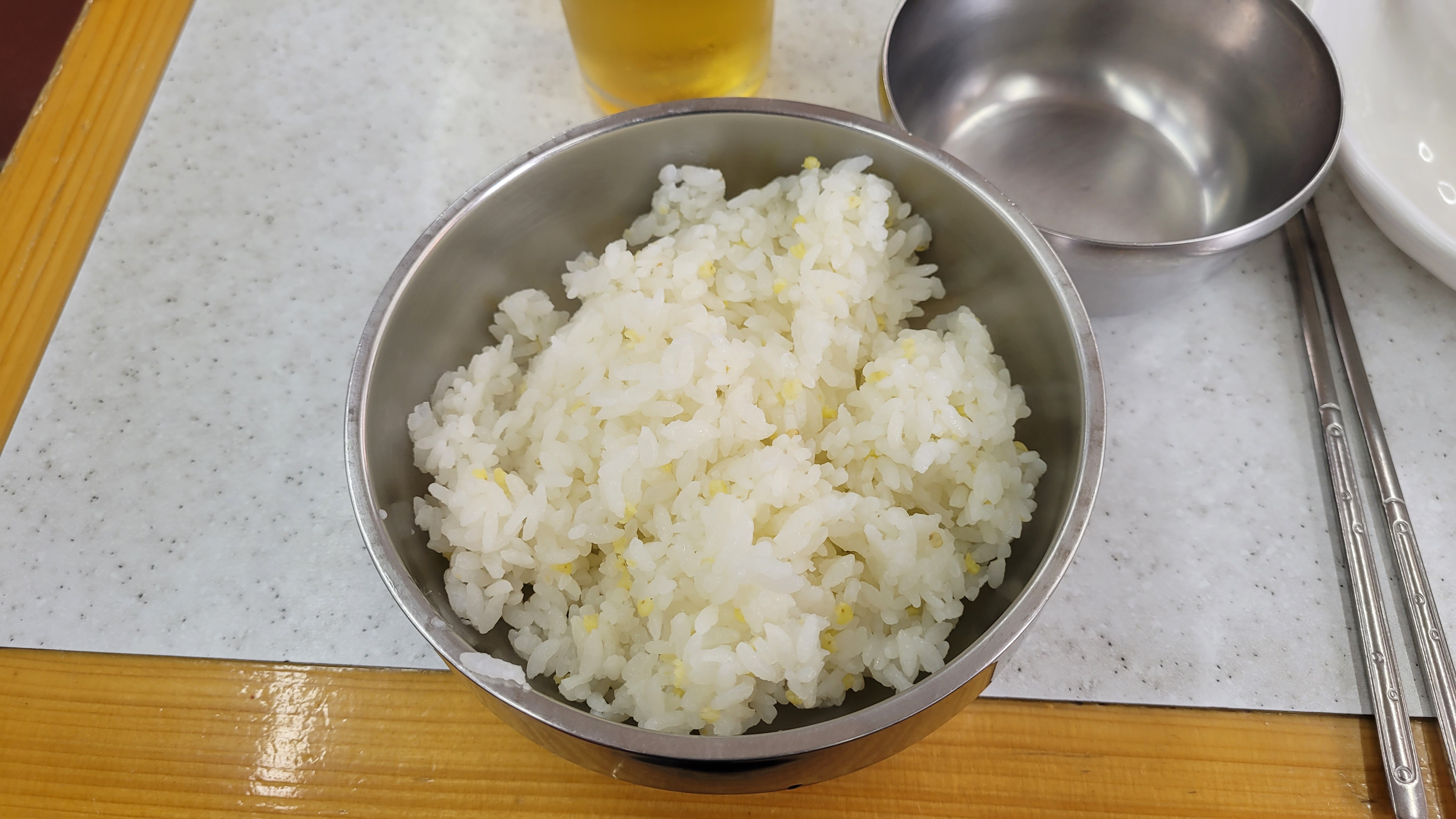 스테인리스 밥그릇 흰밥 노란 알갱이, 맥주잔 젓가락 배경