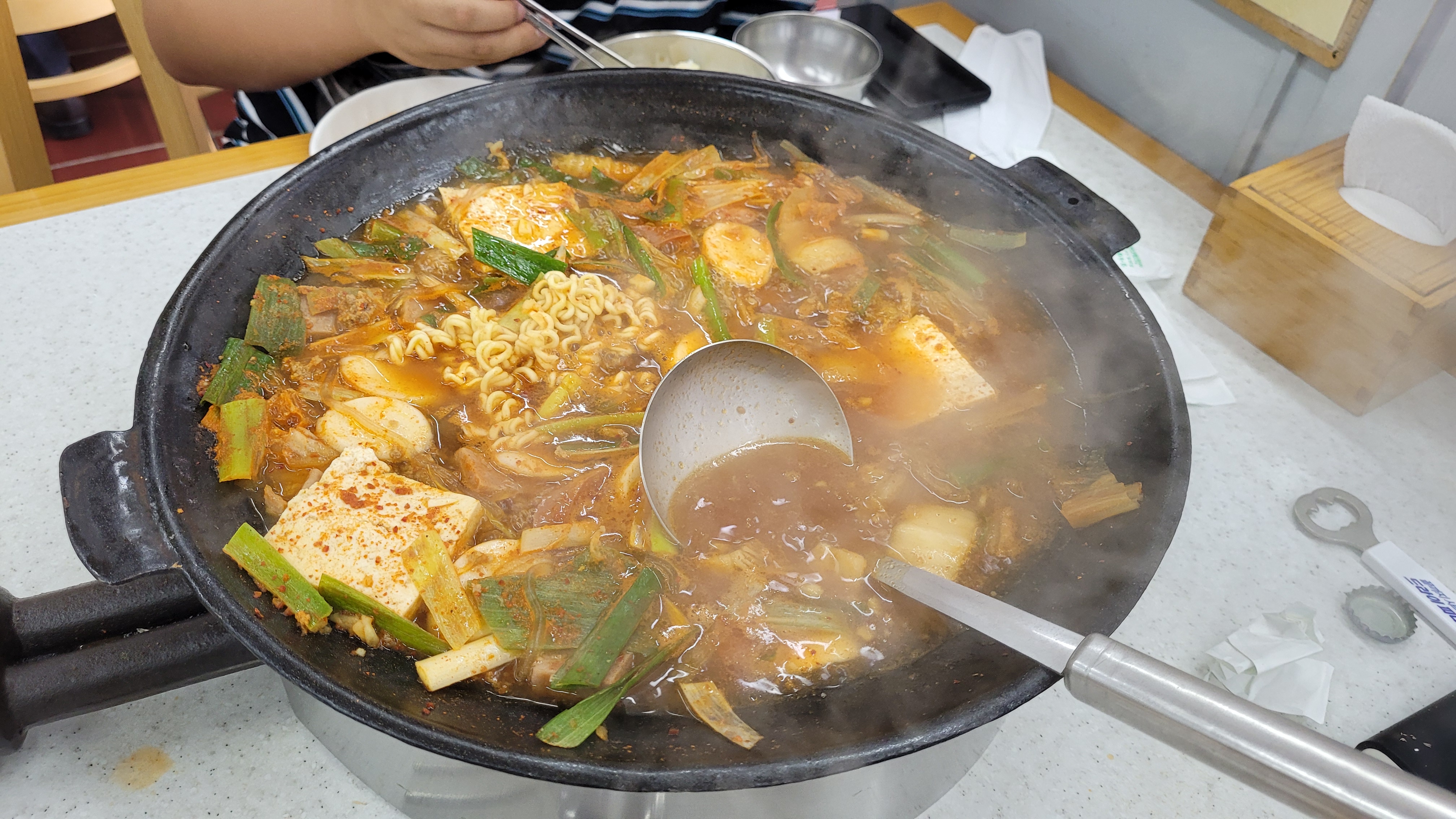 김 나는 얼큰한 한국 찌개, 라면, 두부, 파, 국자.