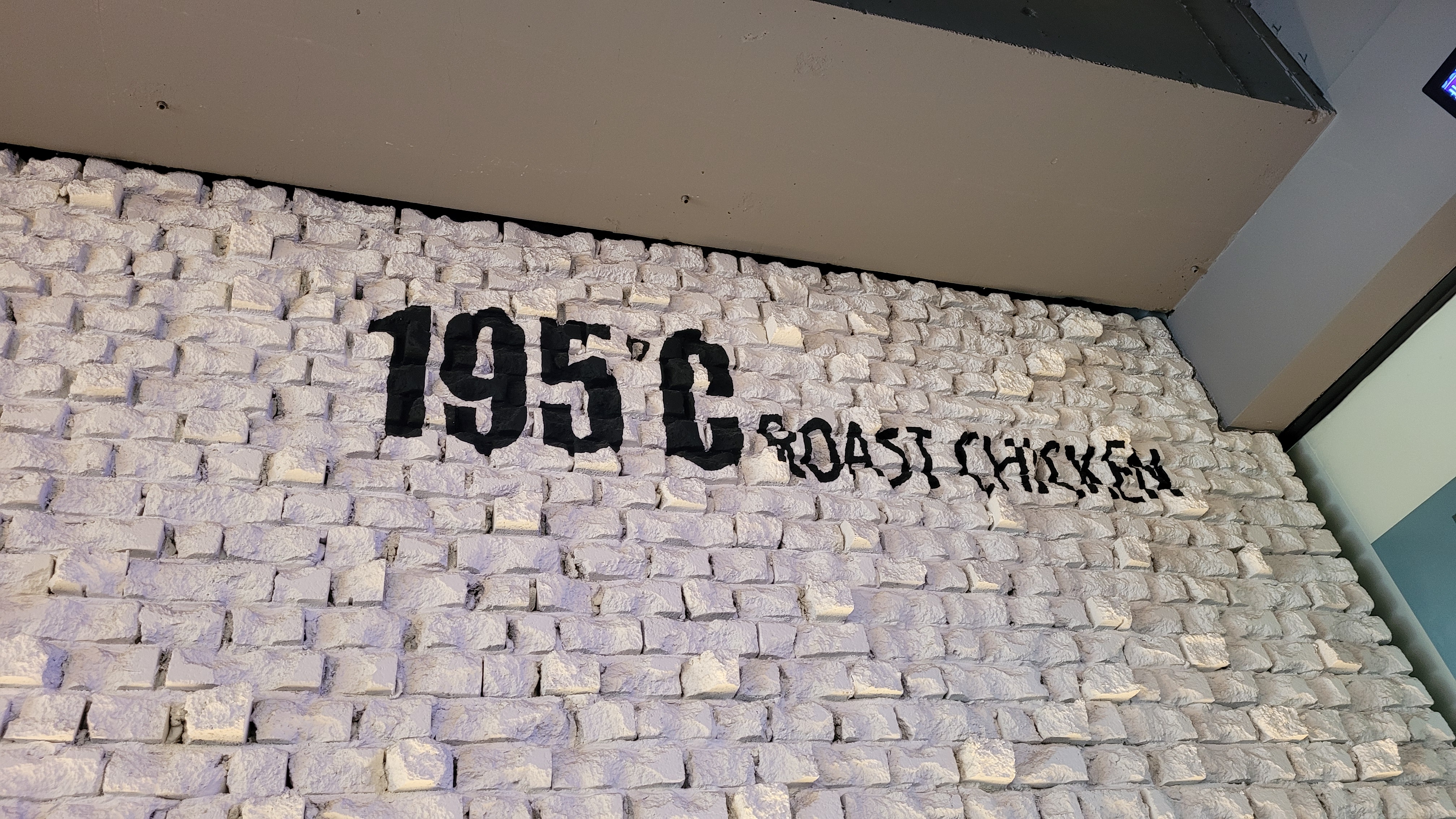 거친 흰색 벽돌 벽, 195C ROAST CHICKEN 검은색 글자