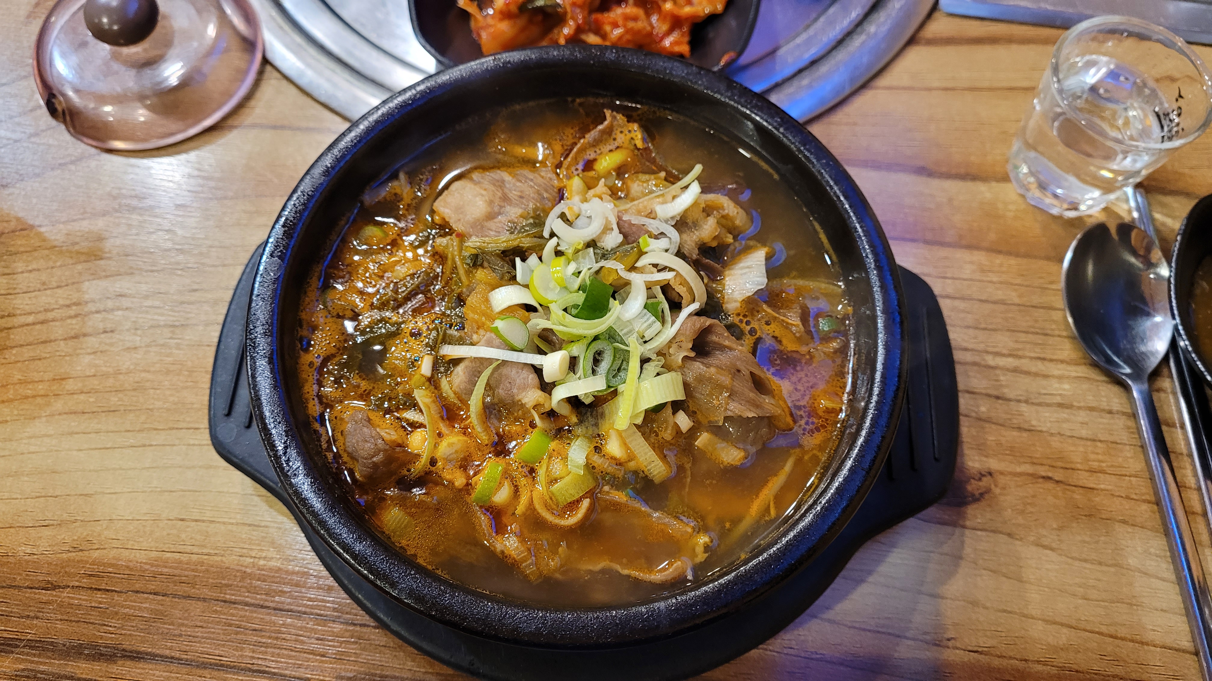 뜨거운 뚝배기 감자탕, 돼지뼈와 파 고명.
