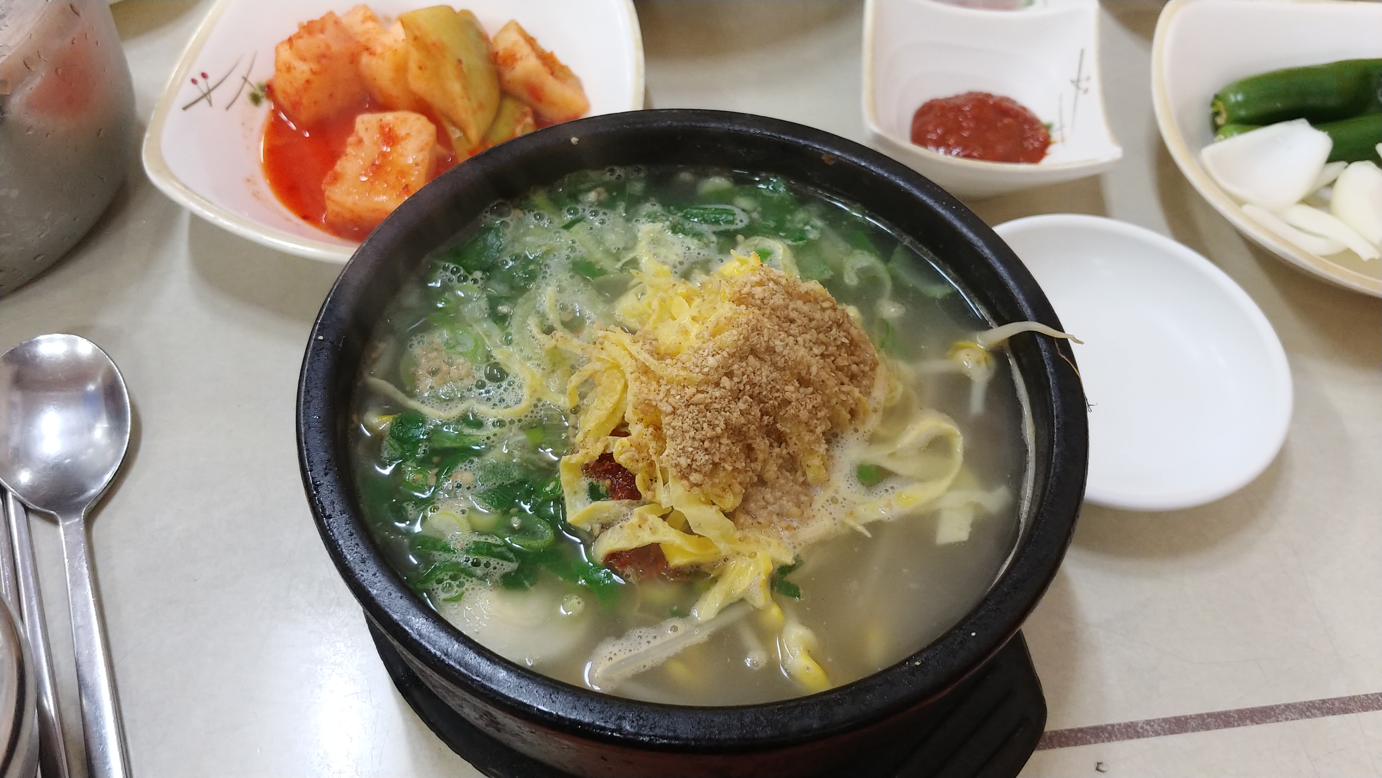 김이 나는 뚝배기 콩나물국밥, 계란 지단, 깍두기 반찬