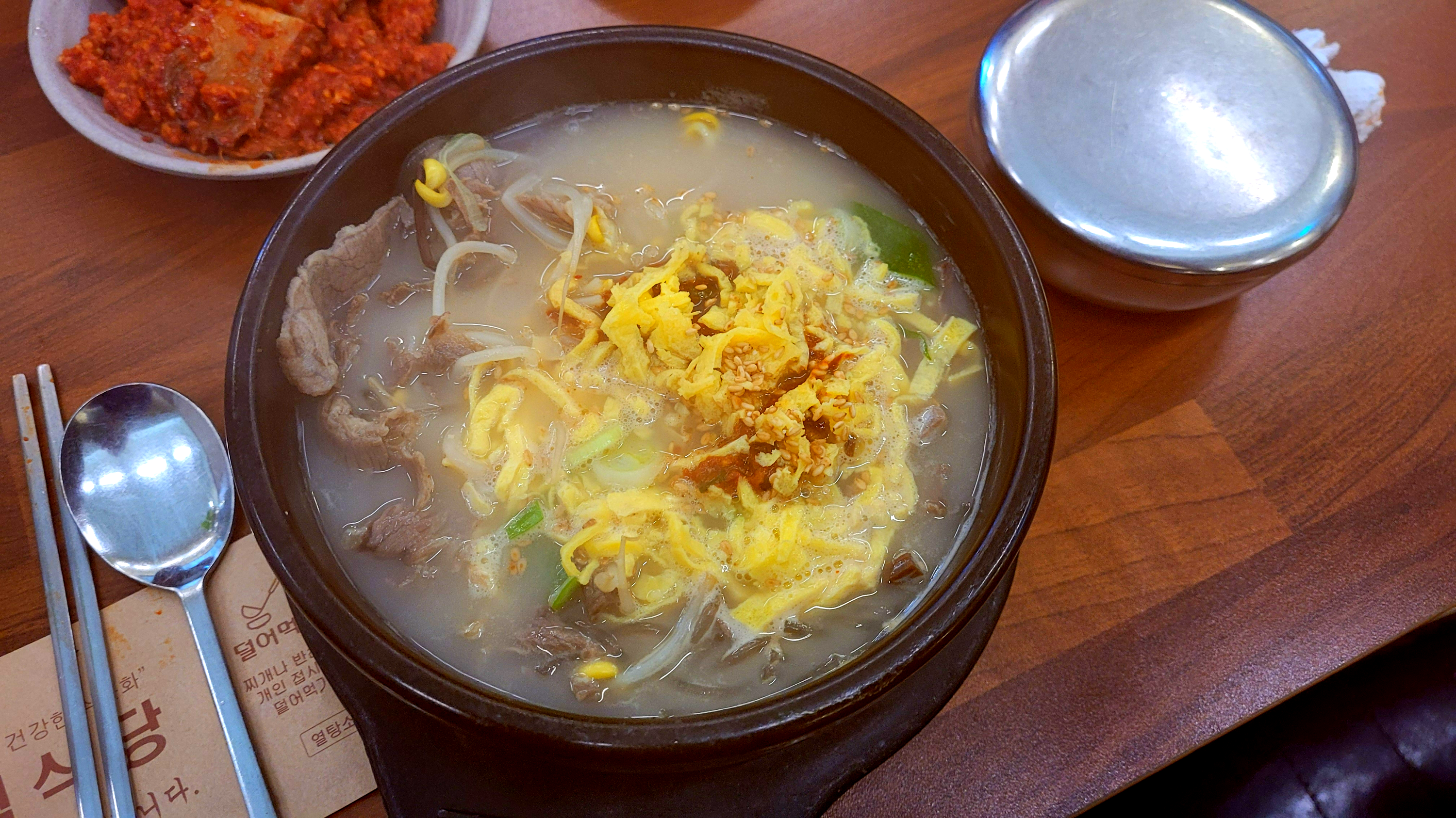뚝배기 곰탕, 얇게 썬 쇠고기, 콩나물, 계란 지단.