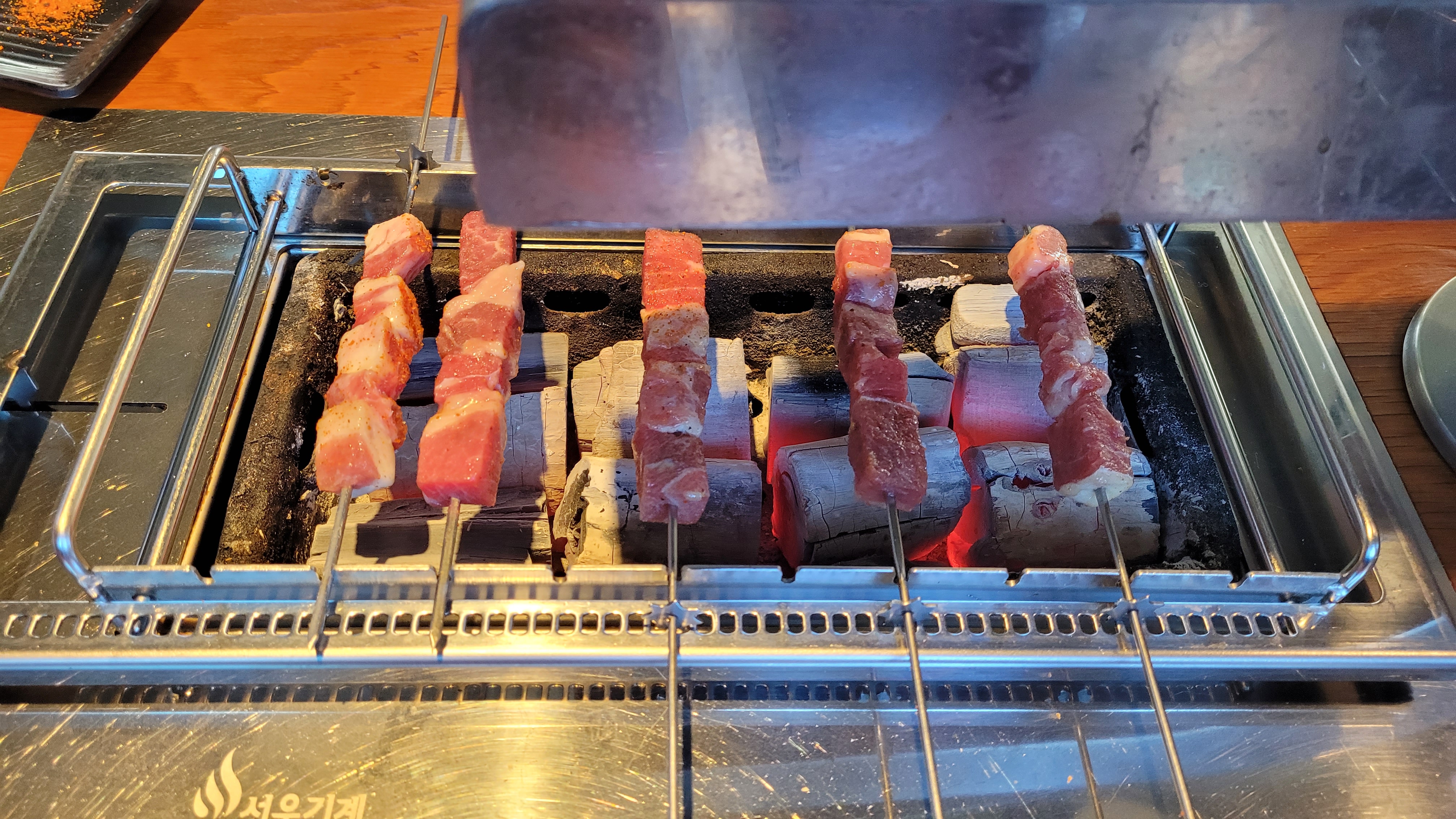 숯불 그릴 위 여러 고기 꼬치, 노릇하게 익는 바비큐