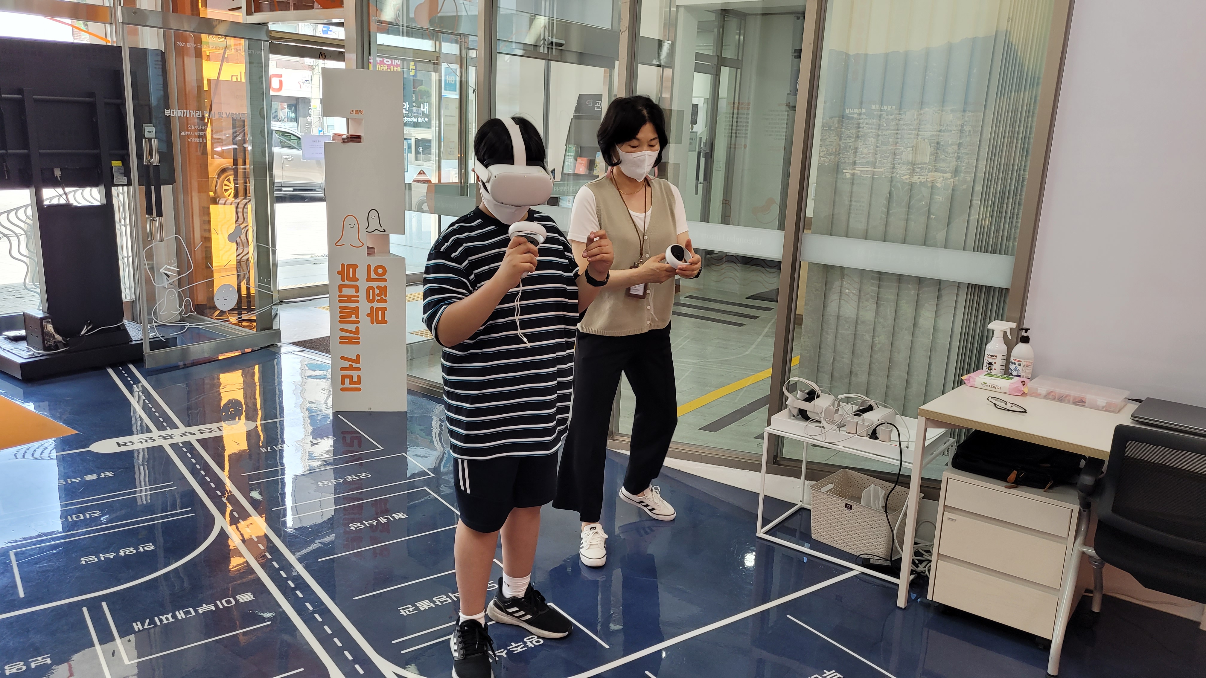 VR 헤드셋 착용 청소년, 어른과 마킹된 바닥에서 가상현실 체험