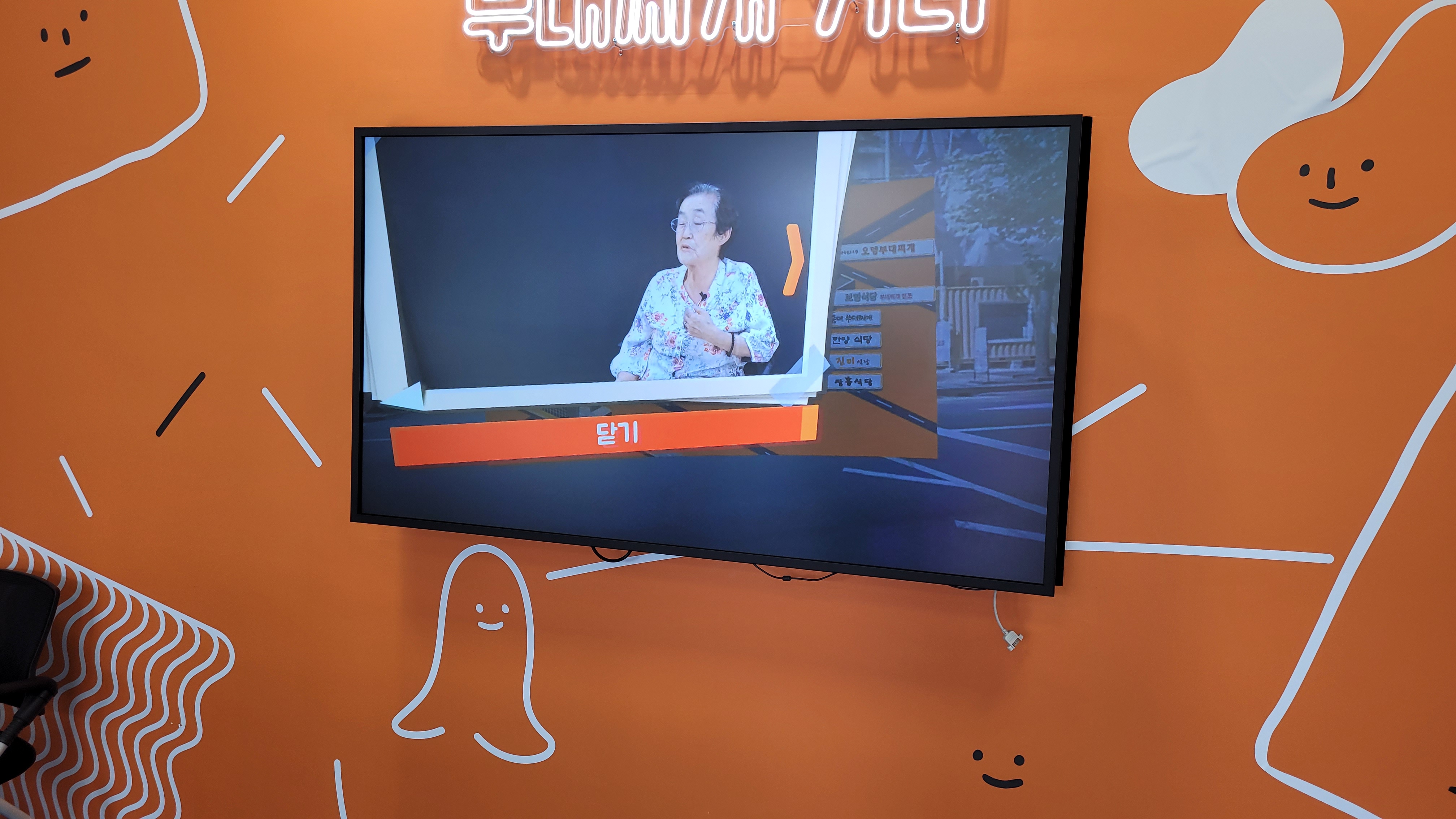 주황 벽 흰색 선화 배경 텔레비전 화면 안경 쓴 연사 강연