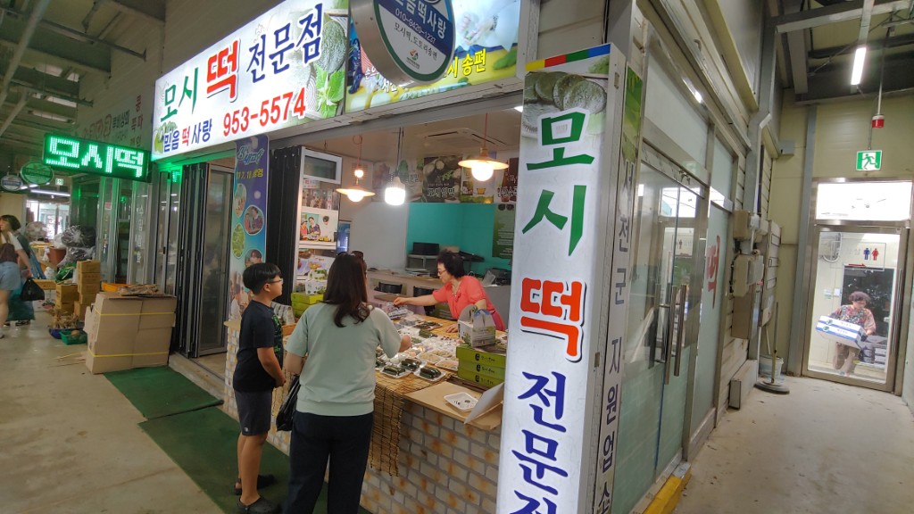 시장 모시떡 전문점, 판매대에 다양한 모시떡 제품 진열.