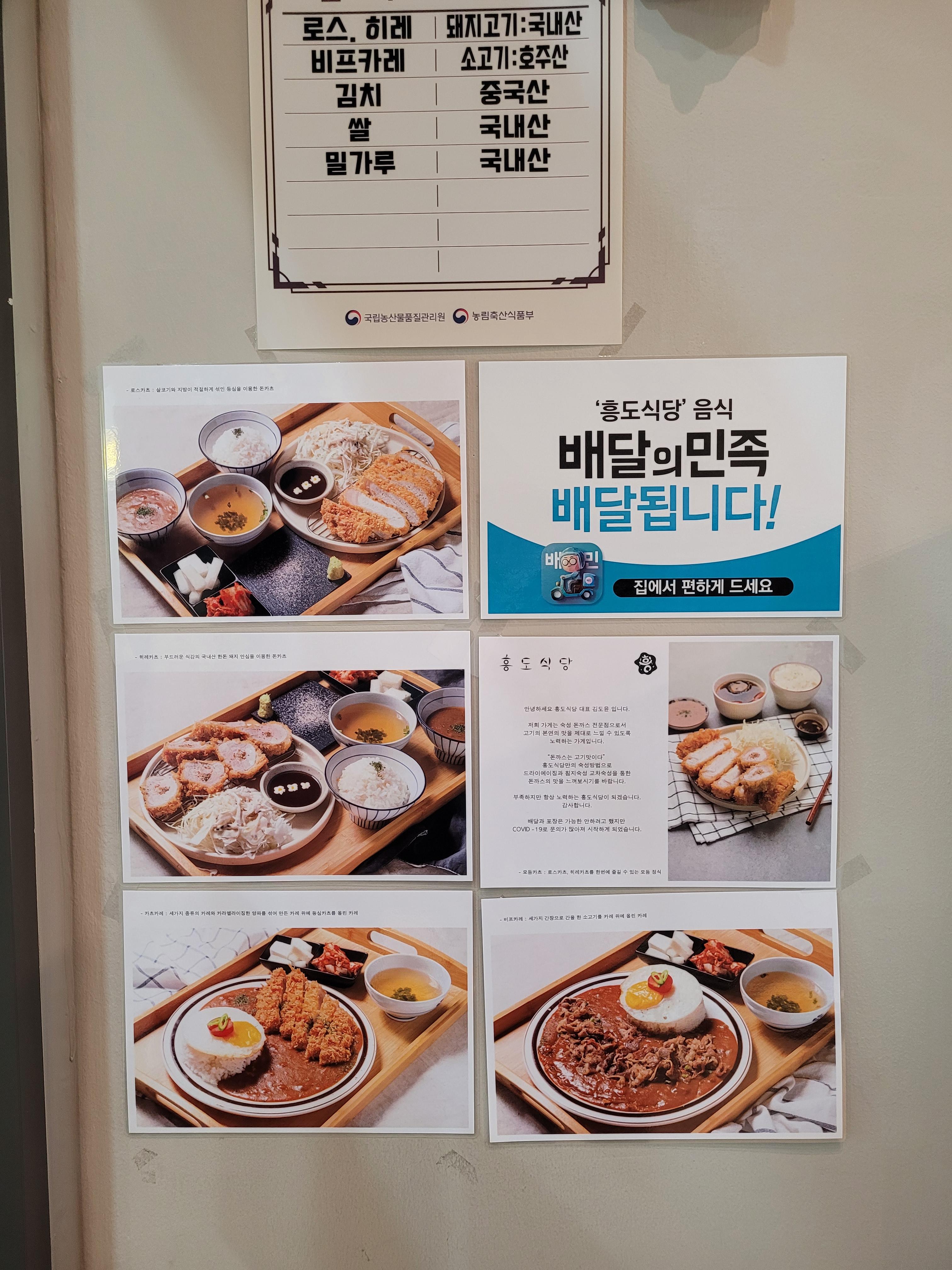 벽에 진열된 돈까스, 카레 정식 메뉴, 원산지표, 배달 서비스 광고.