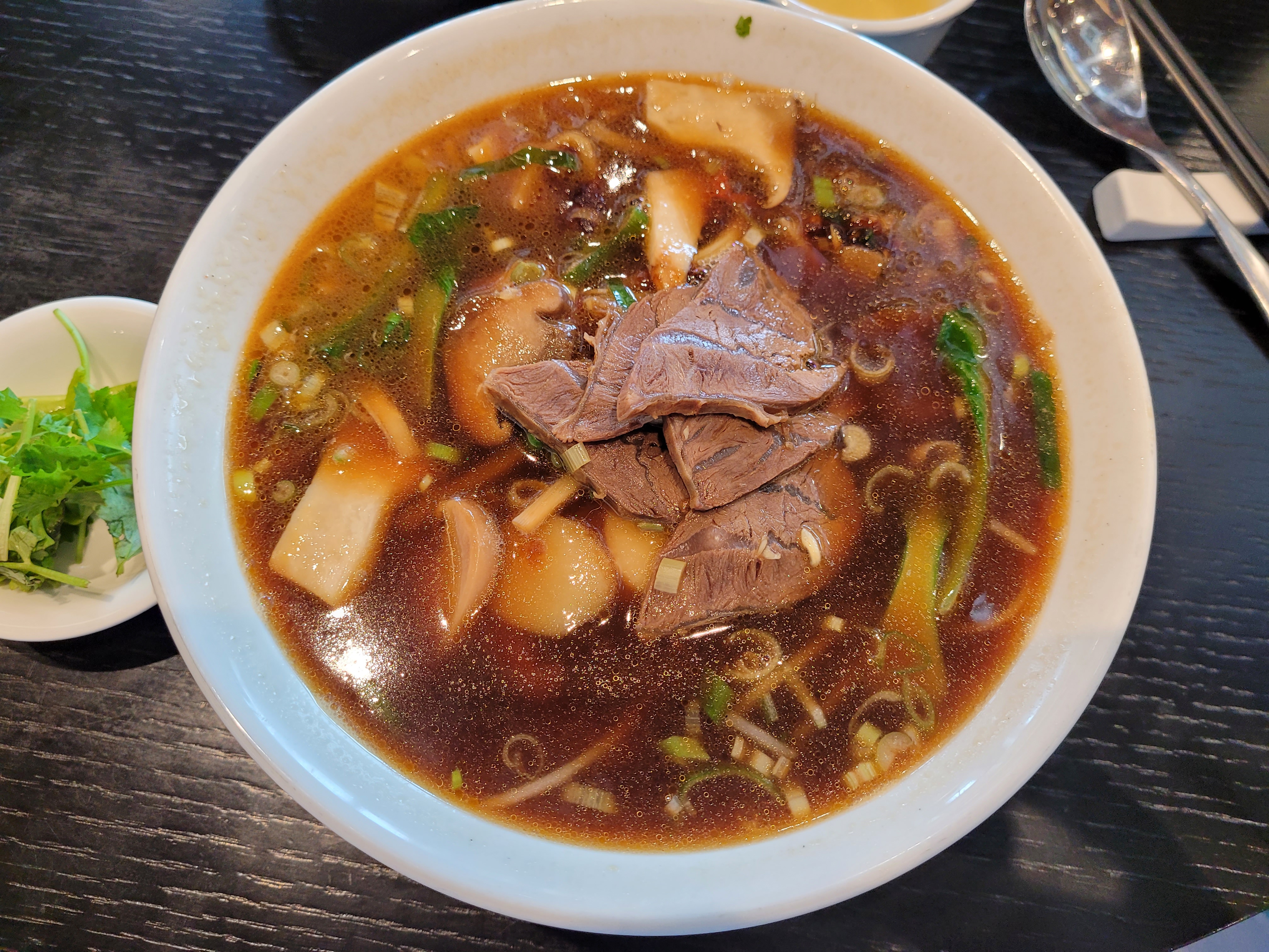 소고기 우육면, 진한 갈색 국물, 부드러운 고기, 신선한 채소