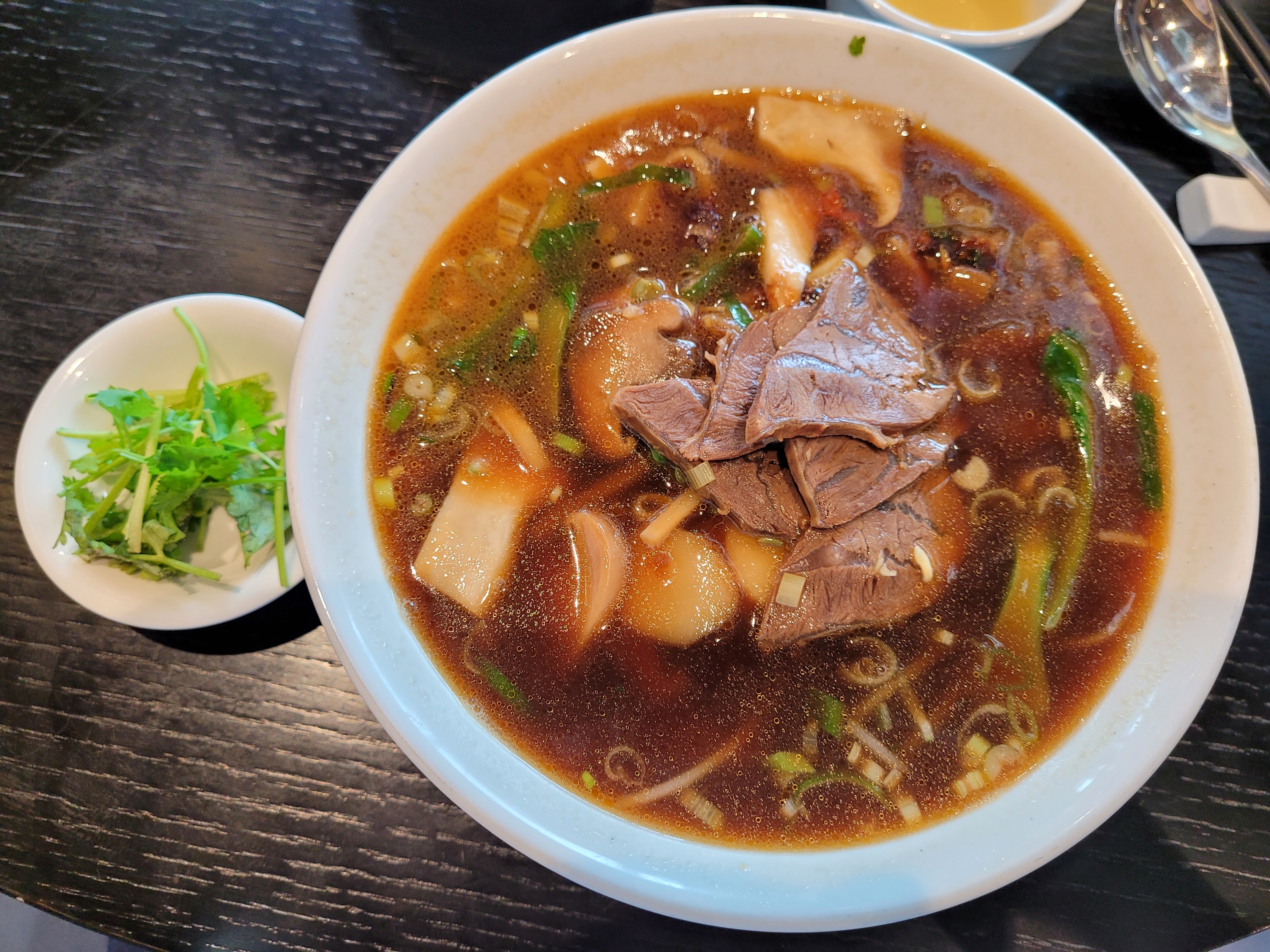 뜨거운 진한 국물 우육면, 부드러운 쇠고기, 버섯, 파, 고수