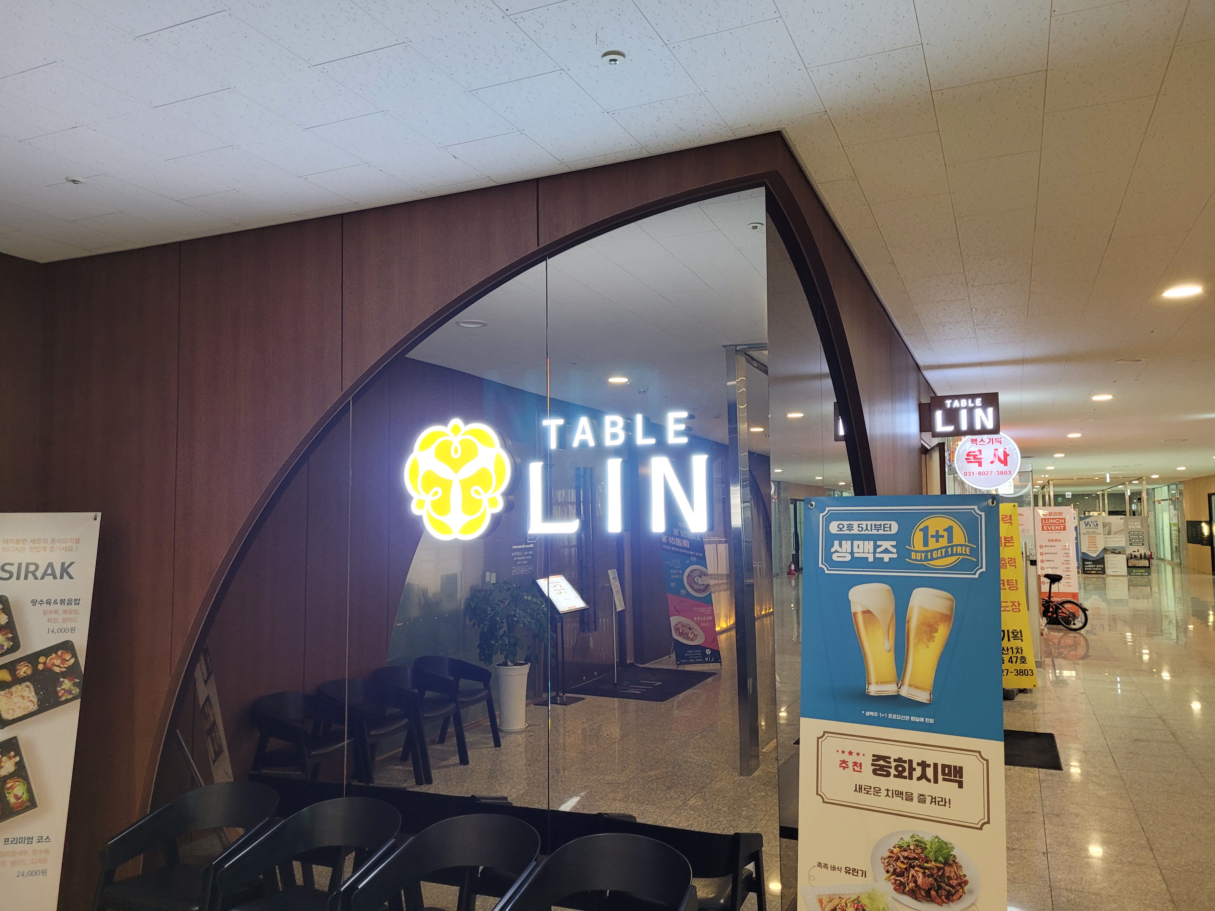 레스토랑 TABLE LIN 간판, 곡선형 유리문, 맥주 프로모션 배너, 복도.
