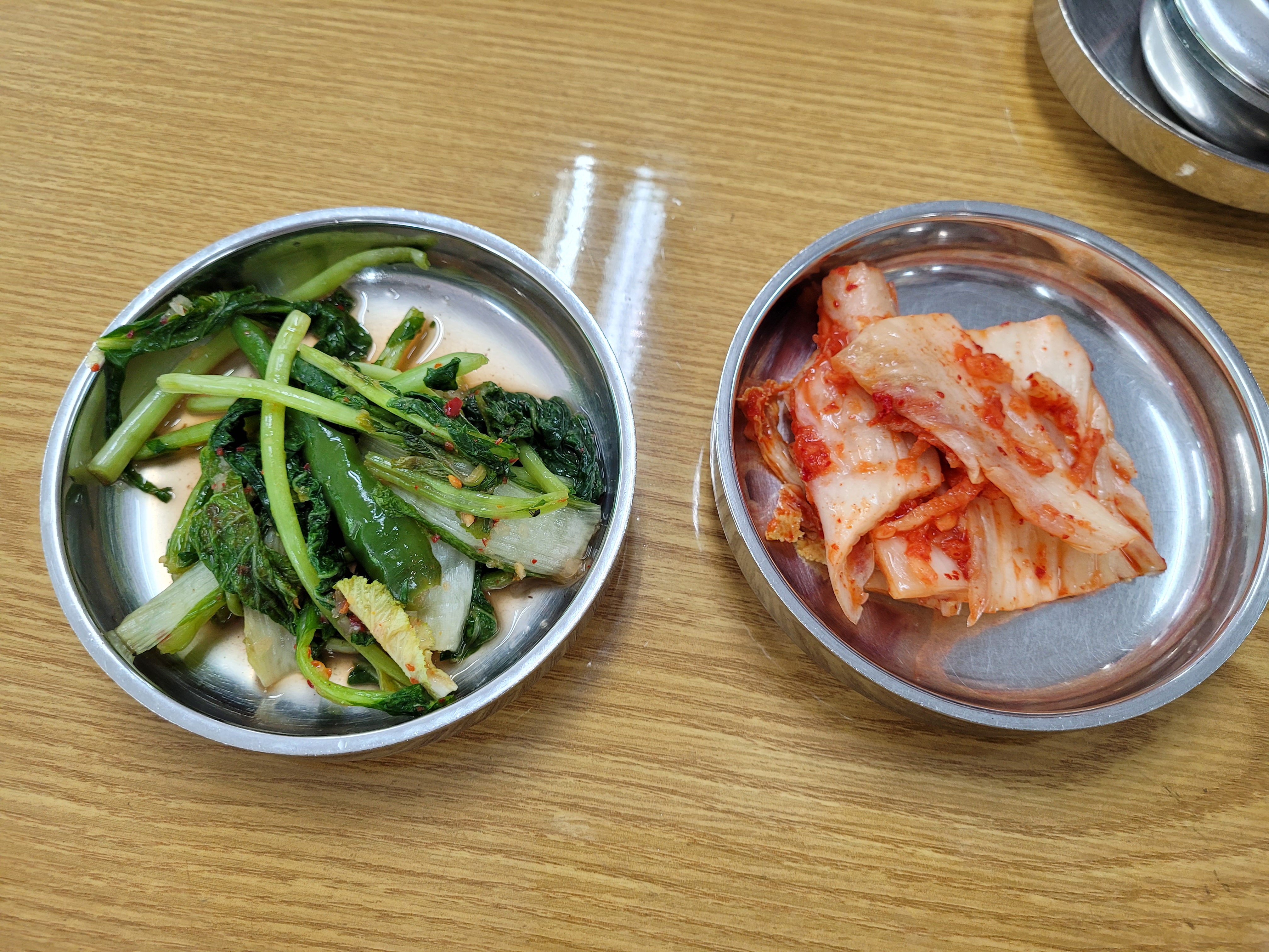 매콤한 배추김치와 시원한 열무김치, 은색 쟁반에 담긴 반찬