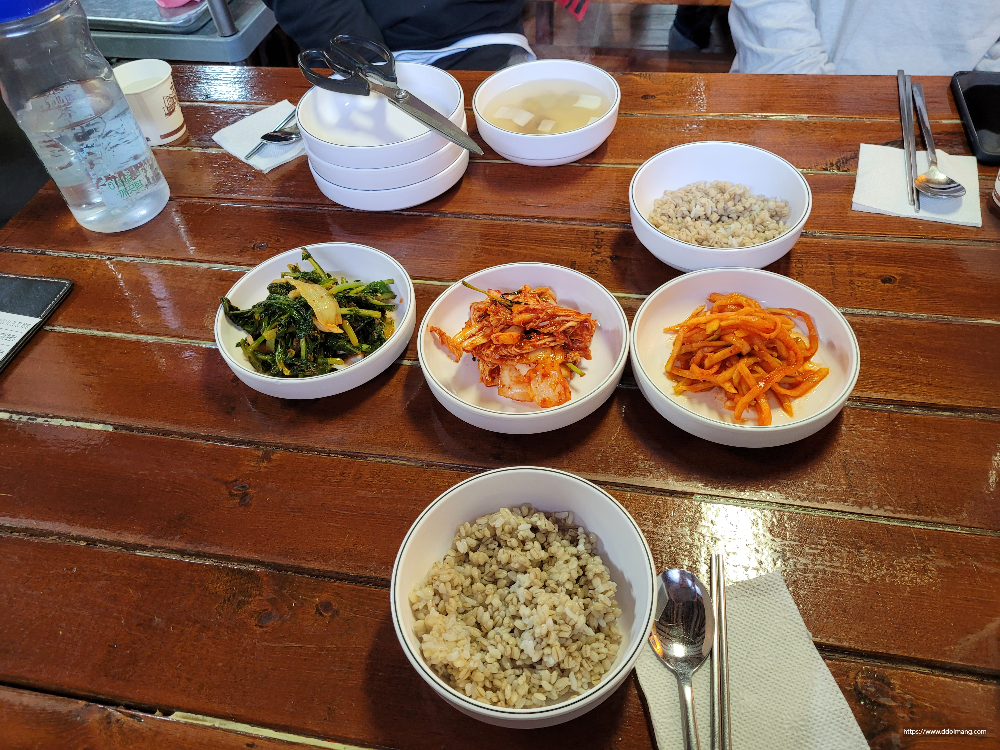 나무 식탁 위 한정식 반찬, 잡곡밥, 김치, 국, 수저