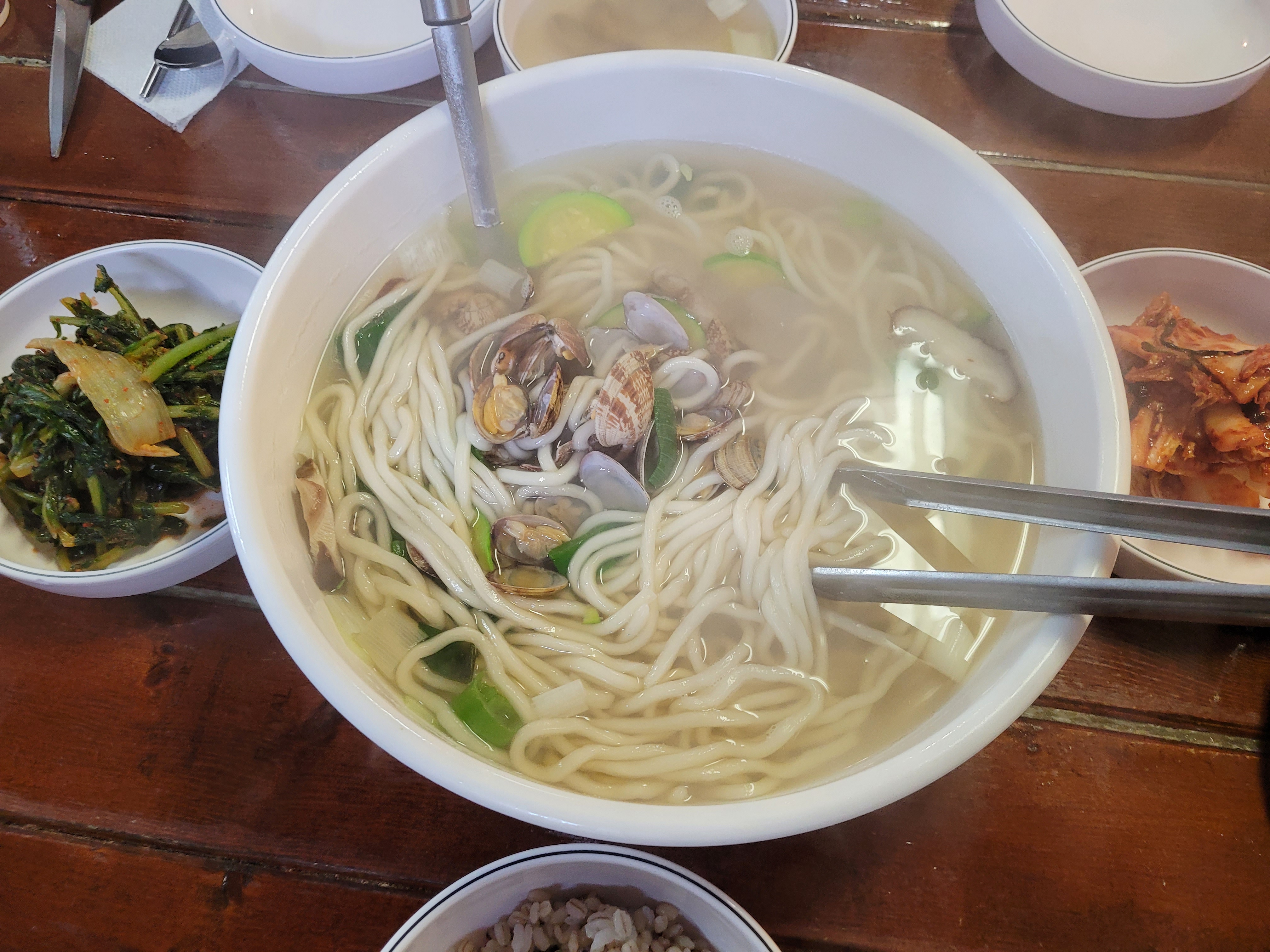 큼지막한 바지락 칼국수, 호박, 파, 조개, 김치 반찬, 집게