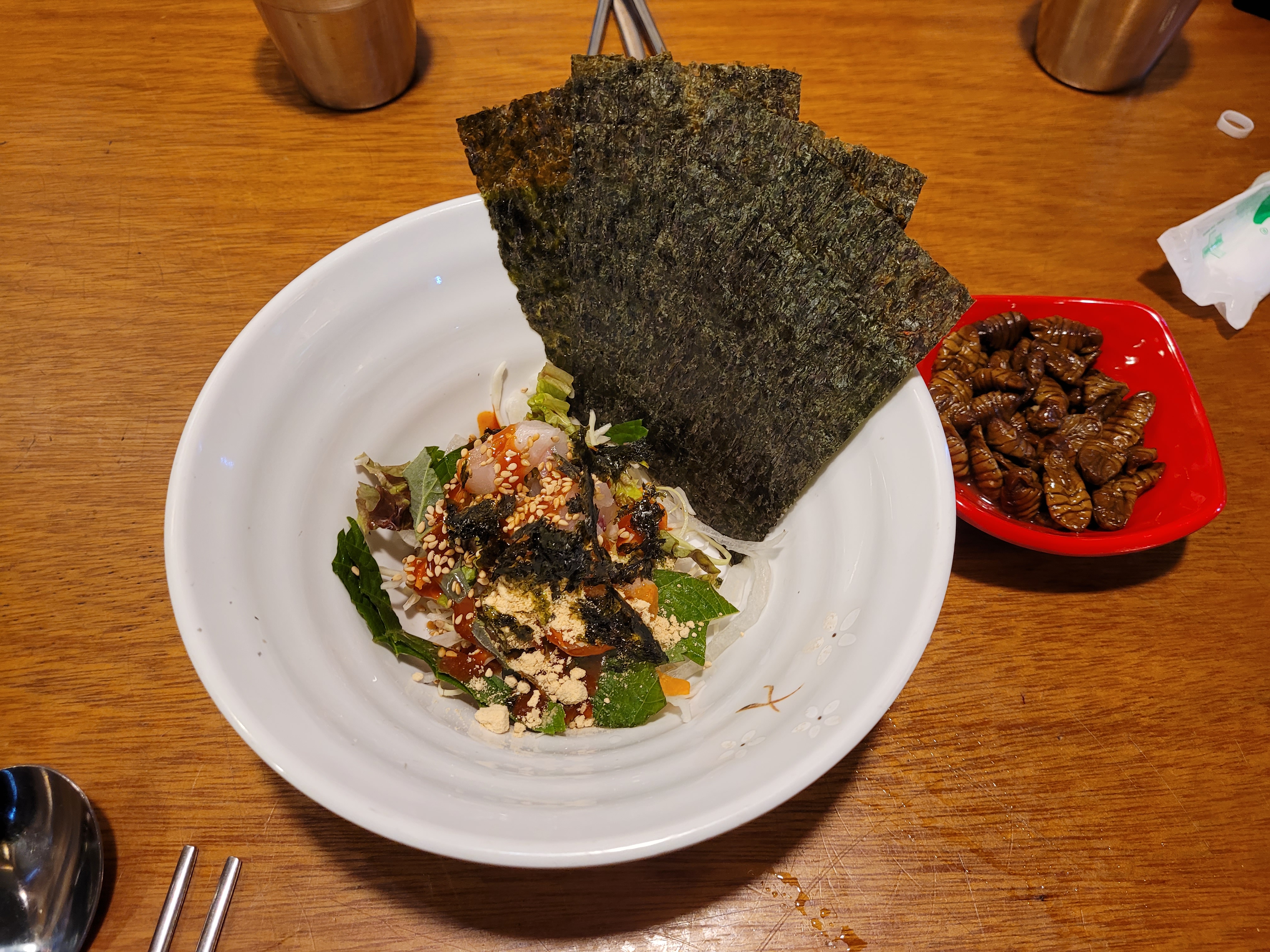 매콤한 회무침, 번데기 요리. 김, 신선한 야채, 참깨.