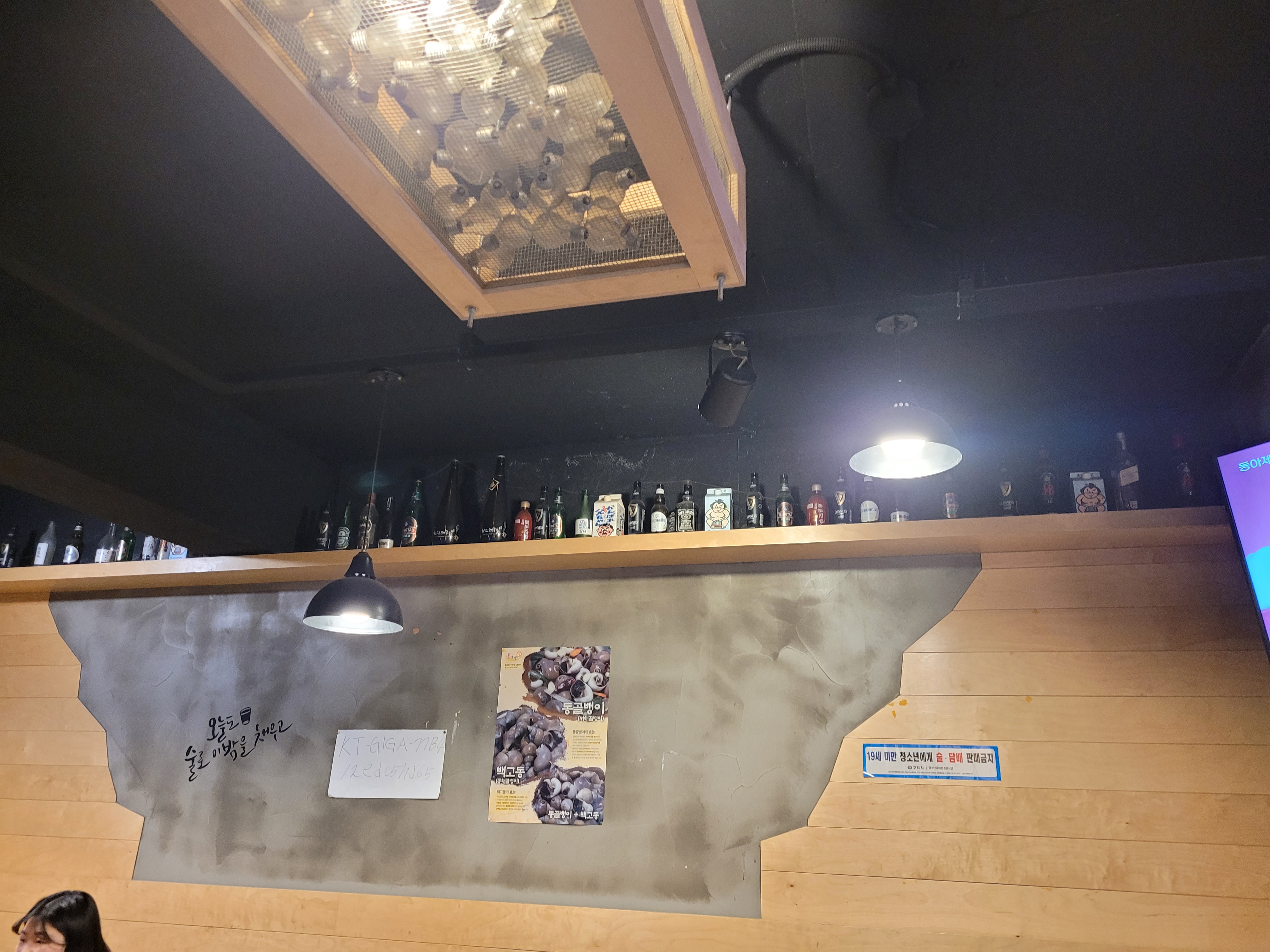 술병 선반, 전구 조명, 독특한 벽 장식 특징인 주점 내부.