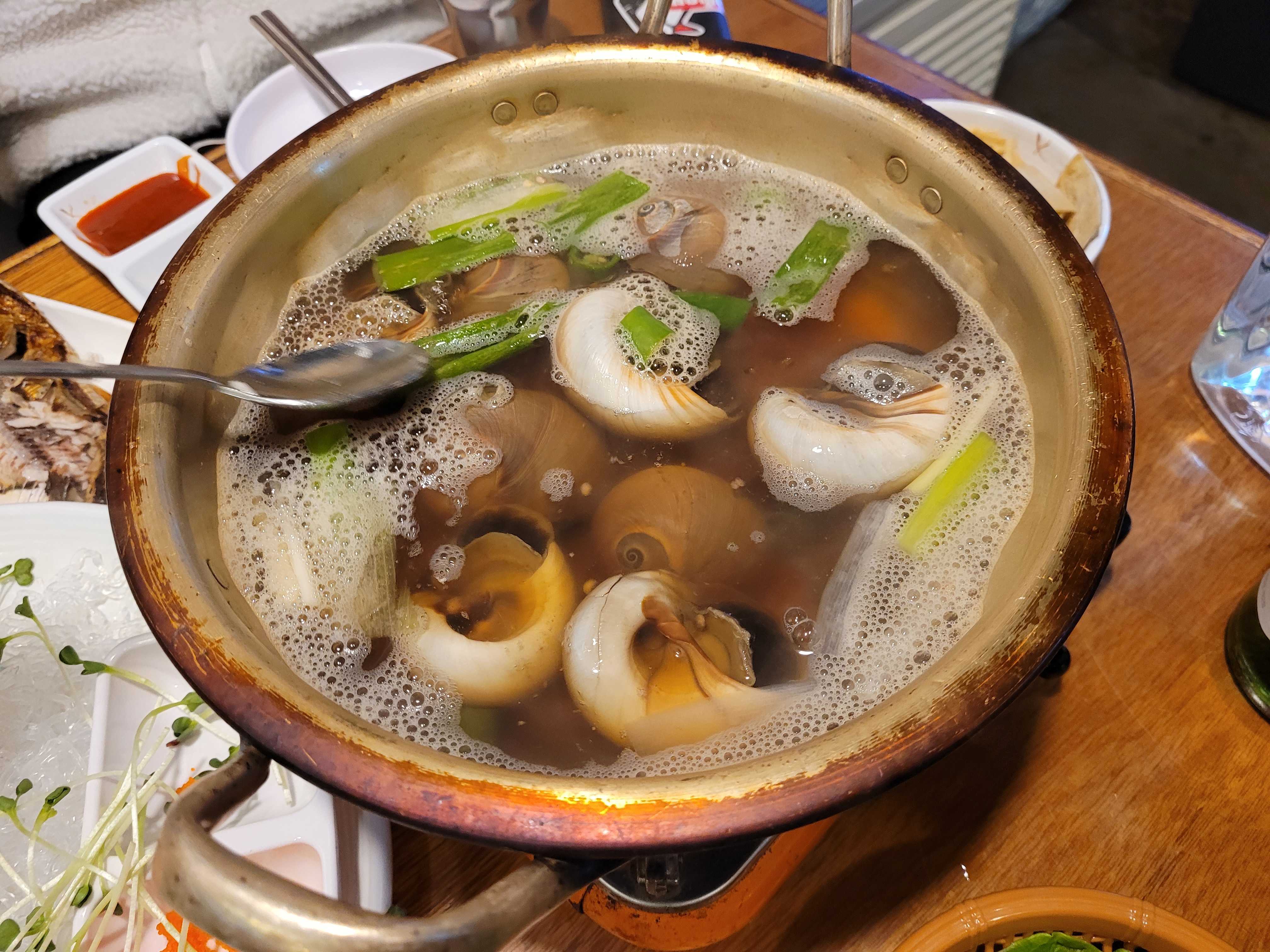 식탁 위 끓는 골뱅이탕, 파 듬뿍 담긴 시원한 국물