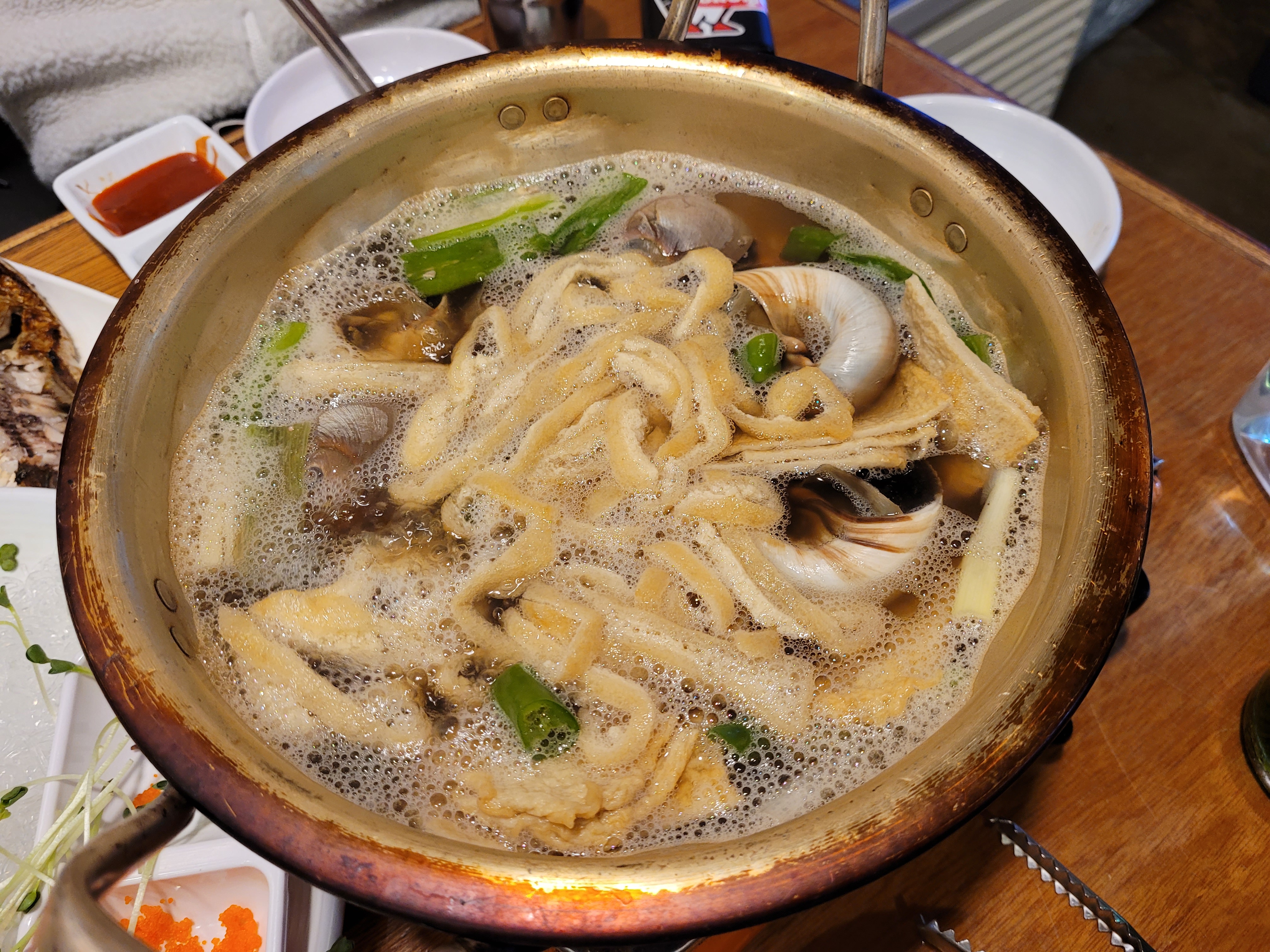 팔팔 끓는 칼국수 전골, 고둥, 파, 풍성한 거품