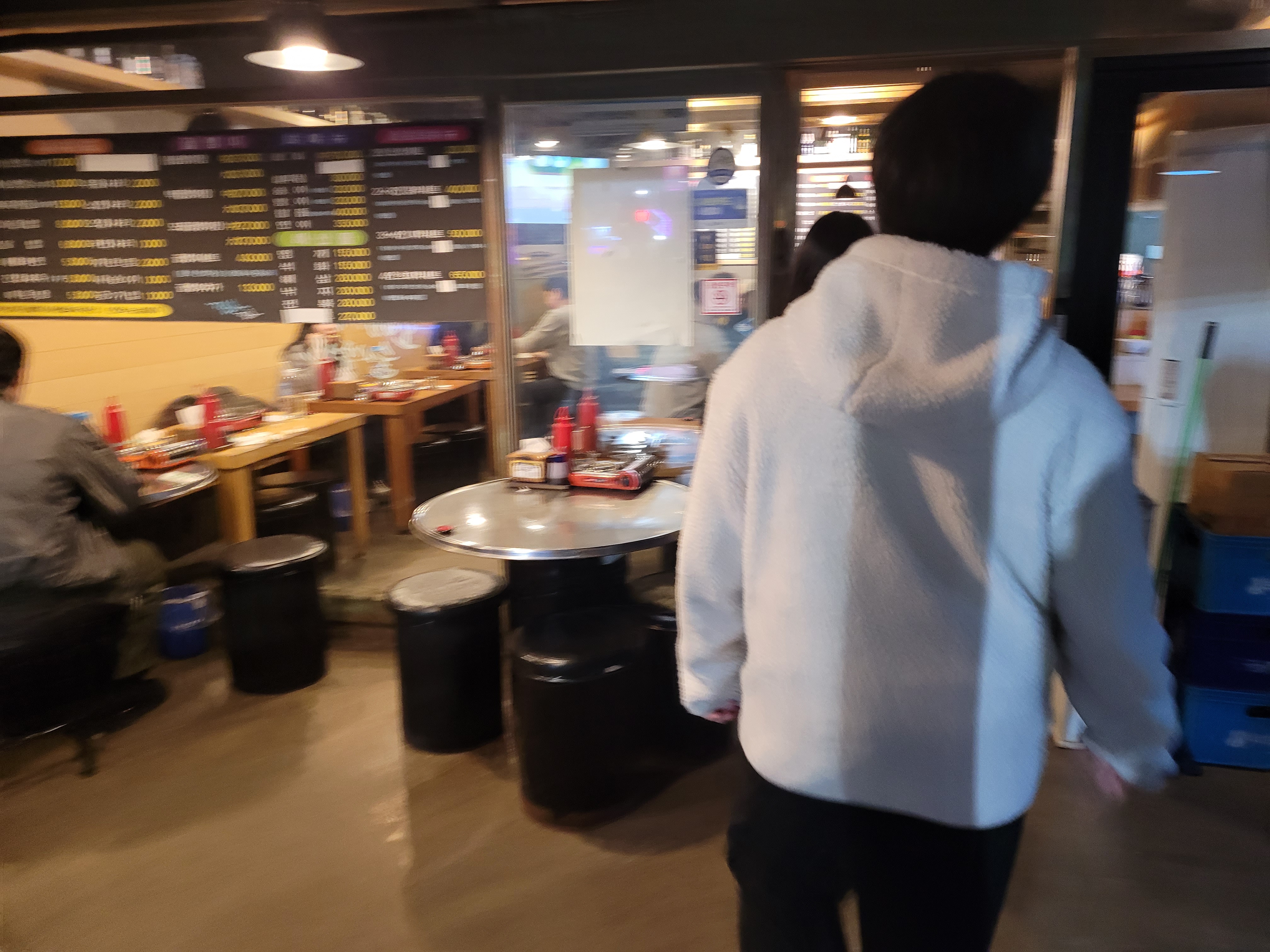 번화한 식당 내부, 검은 메뉴판, 금속 원형 식탁