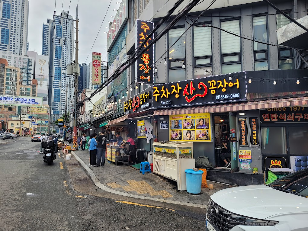 주차장산 꼼장어 식당, 번화한 도시 거리, 높은 빌딩.