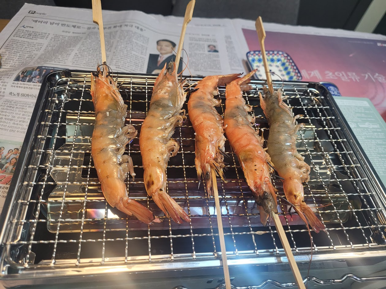숯불 석쇠 위 익어가는 다섯 마리 꼬치 새우
