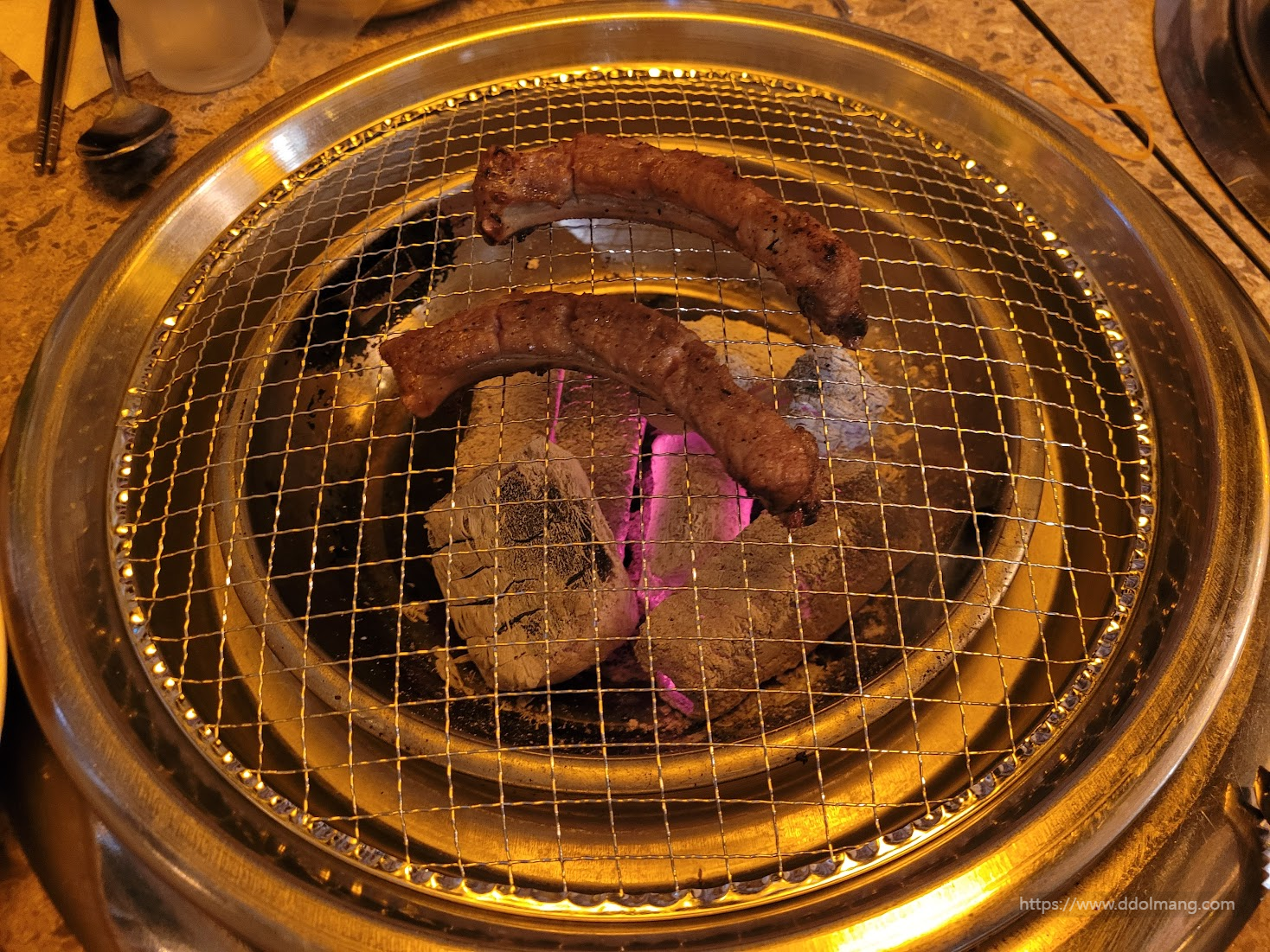타오르는 숯불 불판 위 맛있는 통통한 돼지갈비 구이