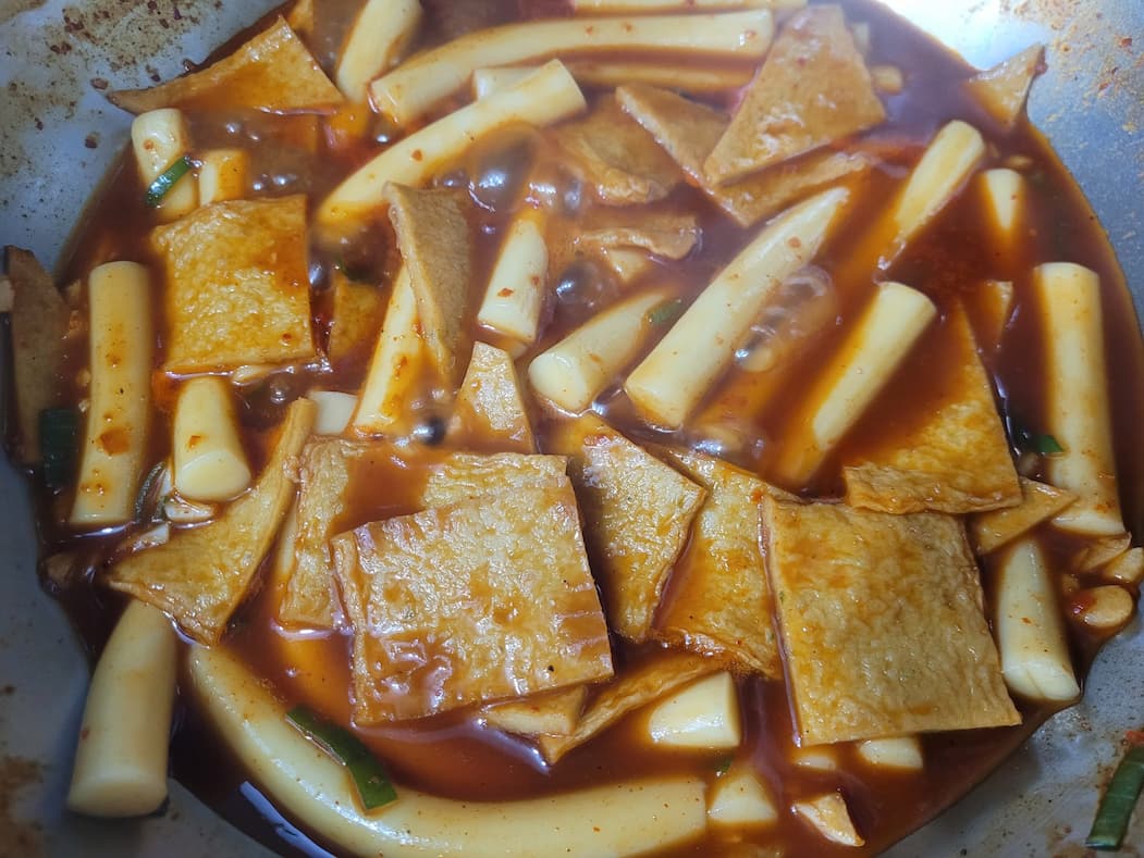매콤한 떡볶이, 떡, 어묵, 빨간 소스에 끓는 중.