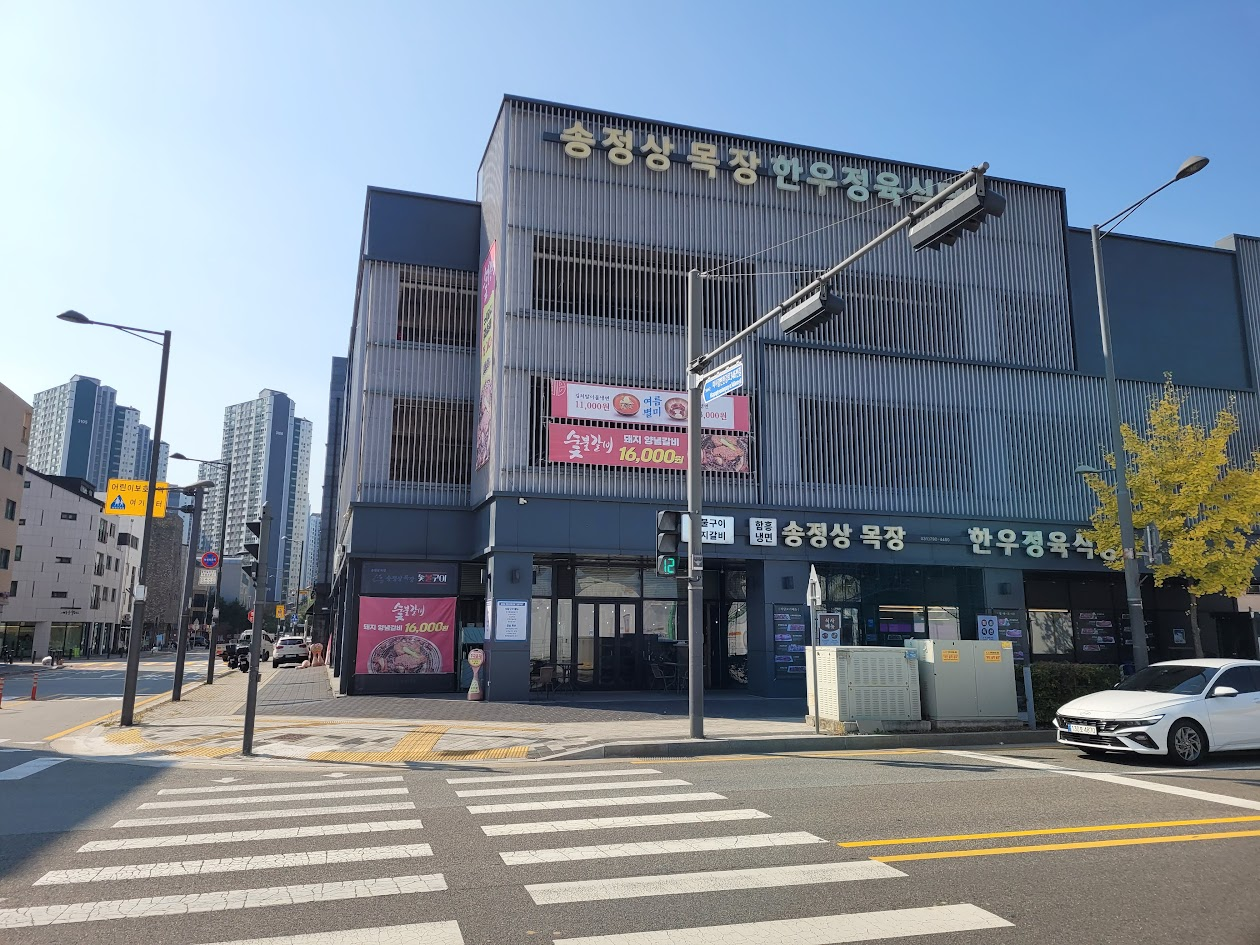 송정상 목장 한우정육식당 회색 현대식 건물 도시 교차로