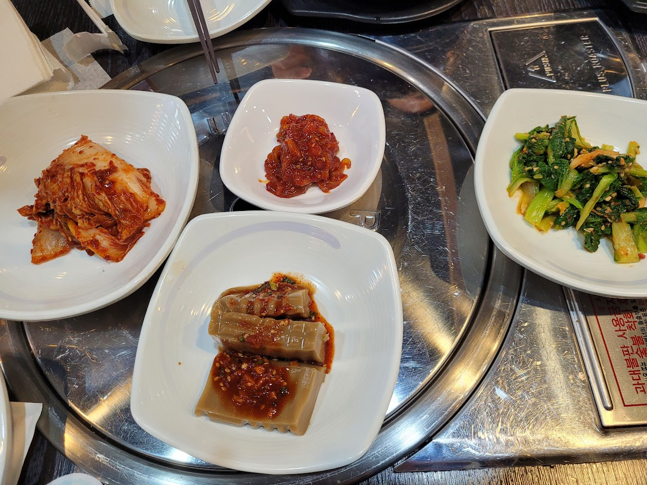 식탁 위 김치, 도토리묵, 나물 등 다양한 한식 반찬