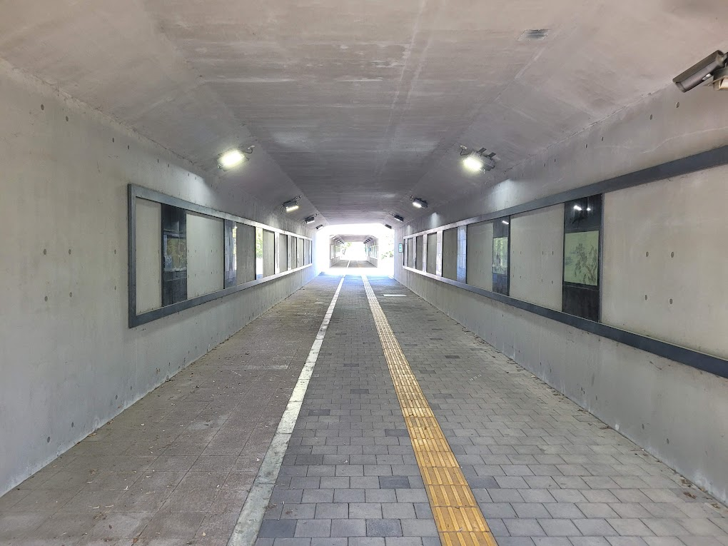 콘크리트 보행자 터널, 벽면 전시, 밝은 출구, 점자블록