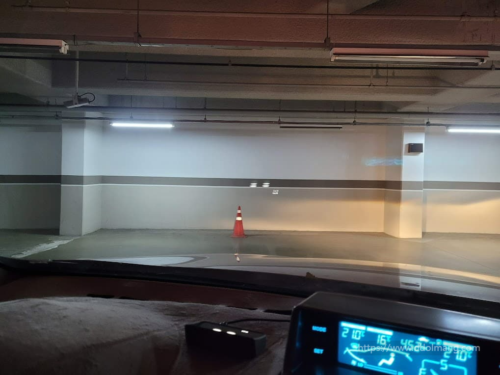 차량 내부에서 본 지하 주차장, 주황색 교통 콘, HUD 정보