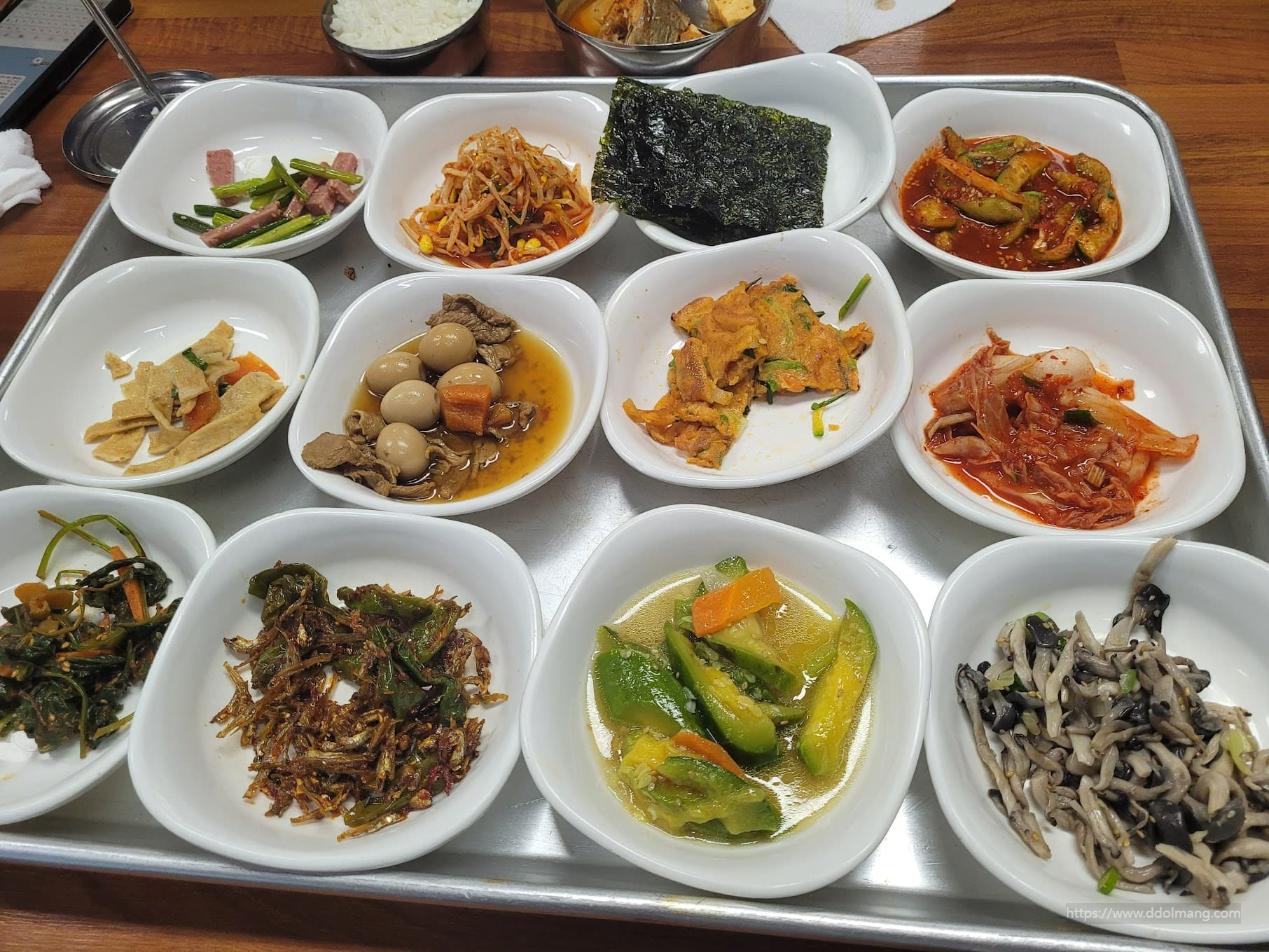 은쟁반 위 다양한 한국 반찬과 밥